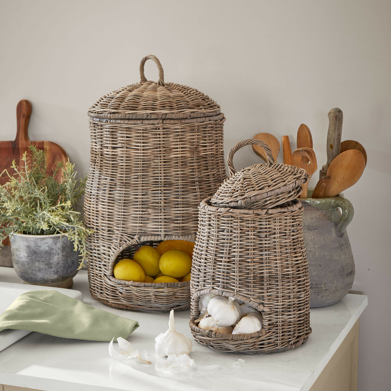 Lot de 2 paniers Arovian Deux paniers en osier naturel pour fruits et légumes posés sur un plan de travail de cuisine