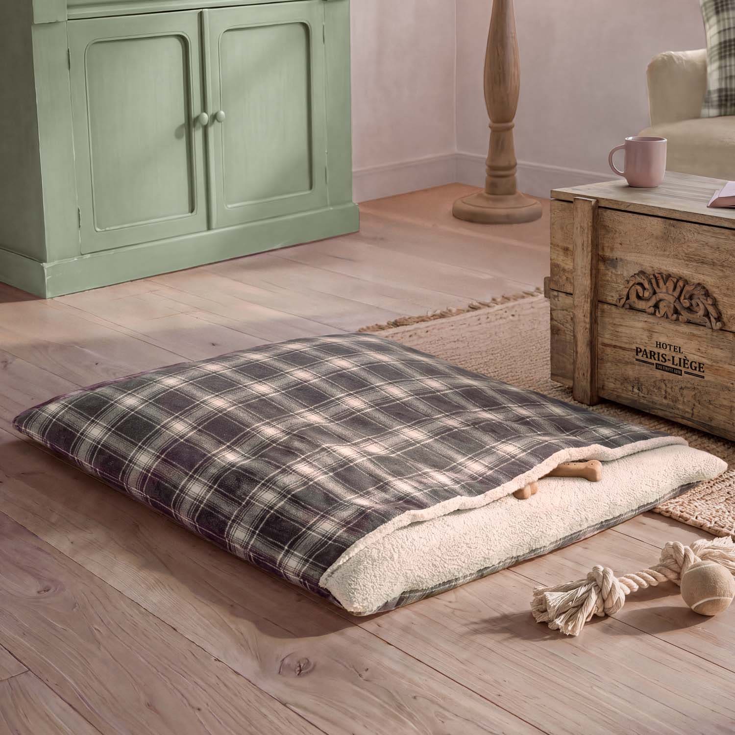 Coussin à carreaux avec intérieur doux crème posé sur un sol en bois dans un salon chaleureux