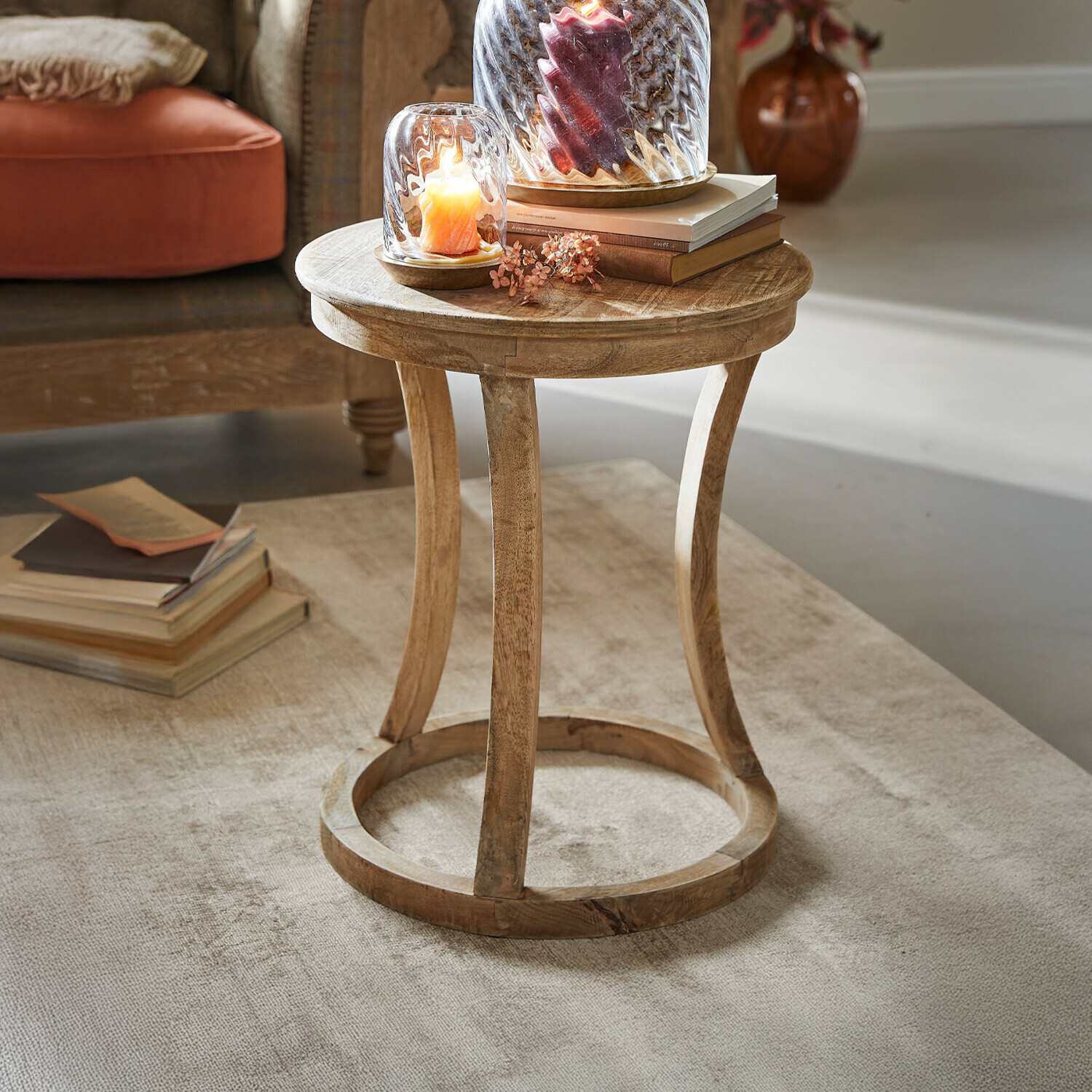 Table d'appoint East Harwich Table d'appoint ronde en bois de manguier naturel sur tapis clair avec bougies décoratives