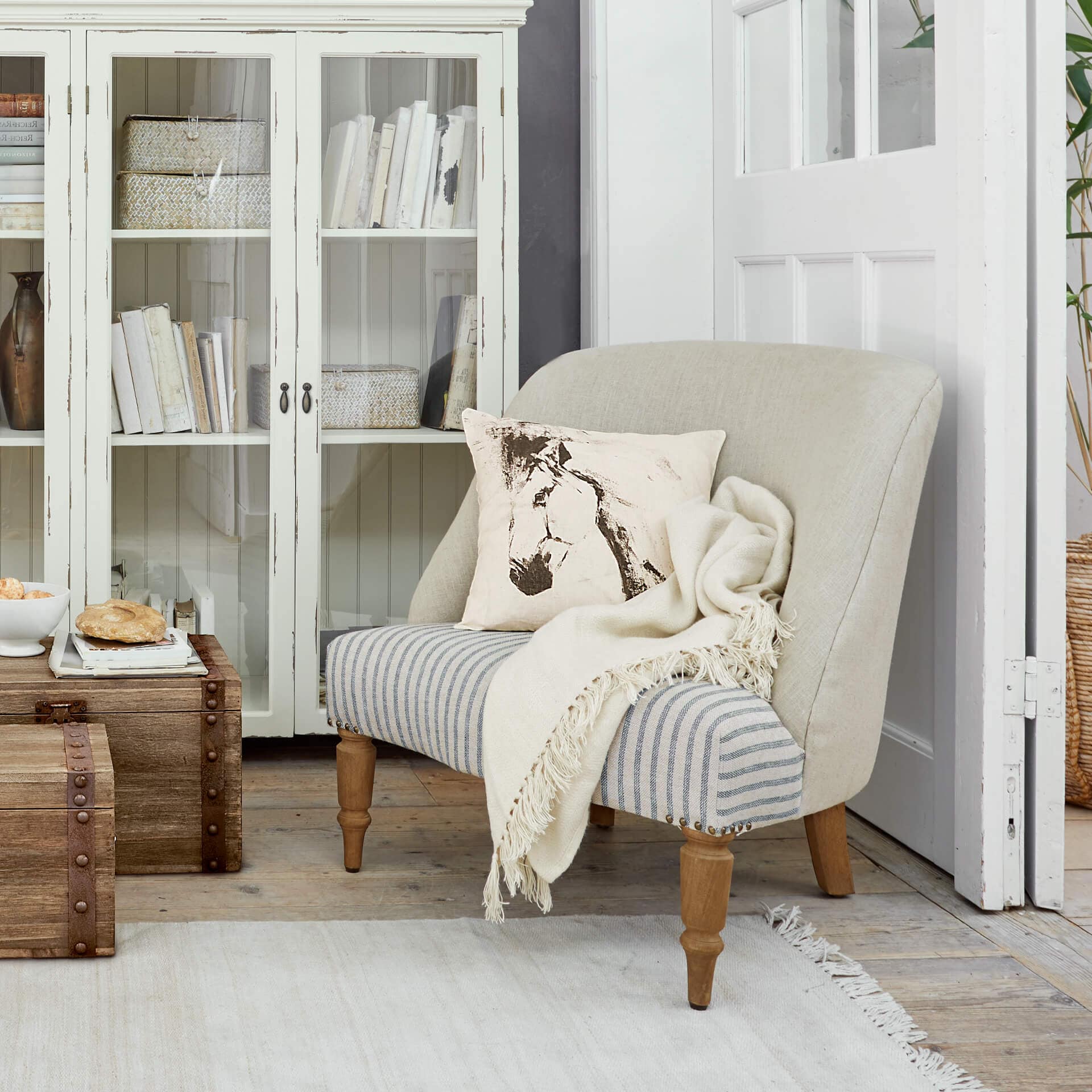 Canapé bicolore en bois et tissu beige et gris avec coussin imprimé cheval et plaid