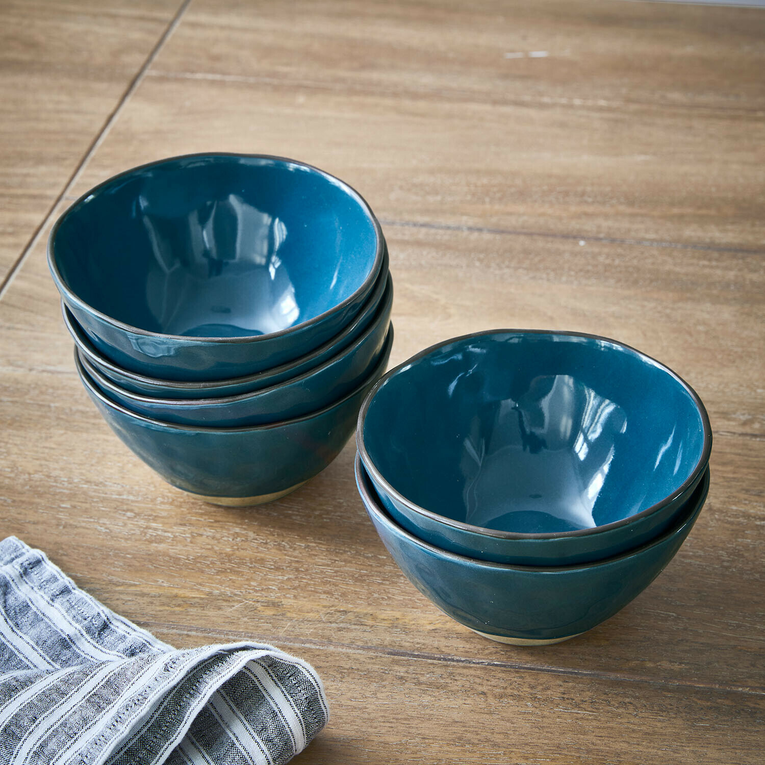 Lot de 6 bols Biarré Ensemble de bols en céramique bleue posés sur une table en bois avec un torchon en lin