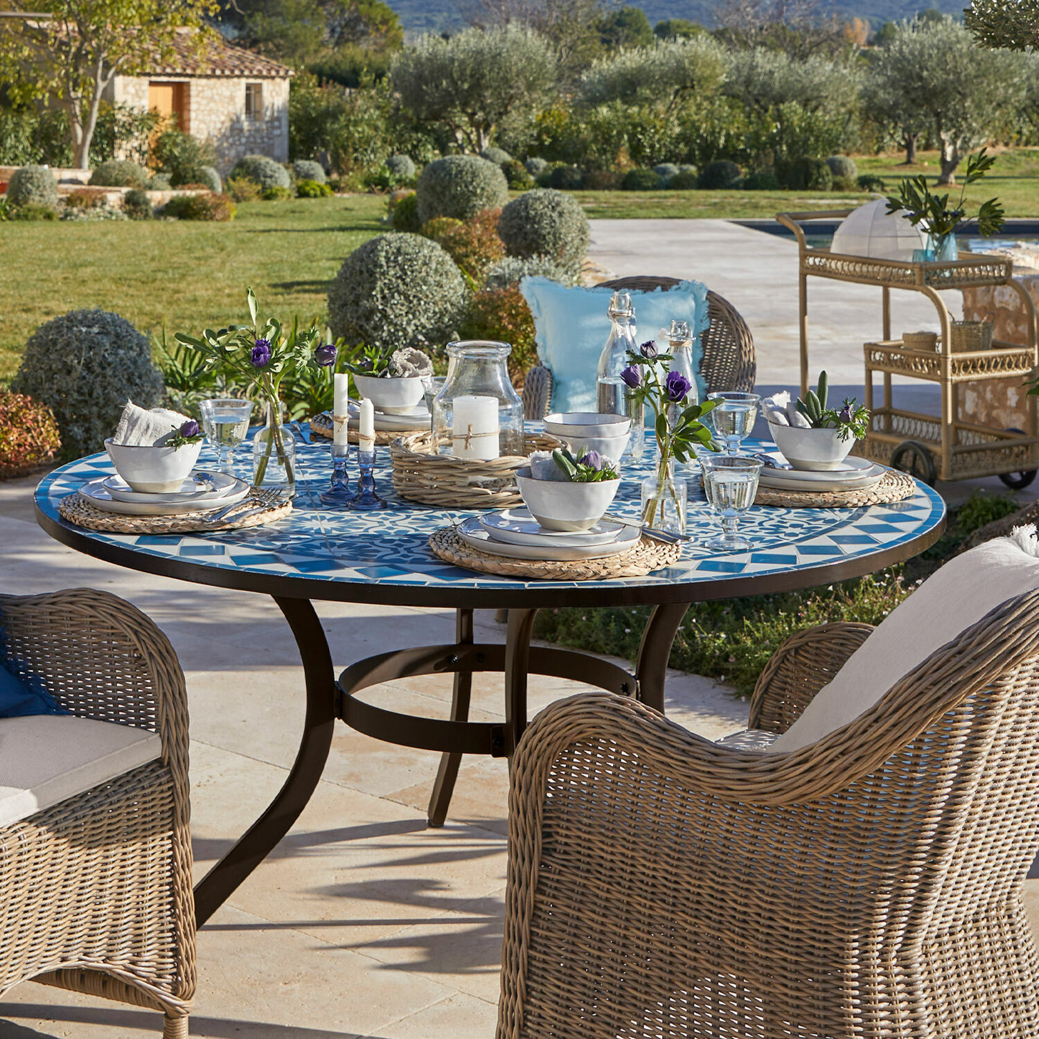 Table Jennarton Table de jardin ronde avec plateau en mosaïque bleu et blanc et chaises en osier sur la terrasse