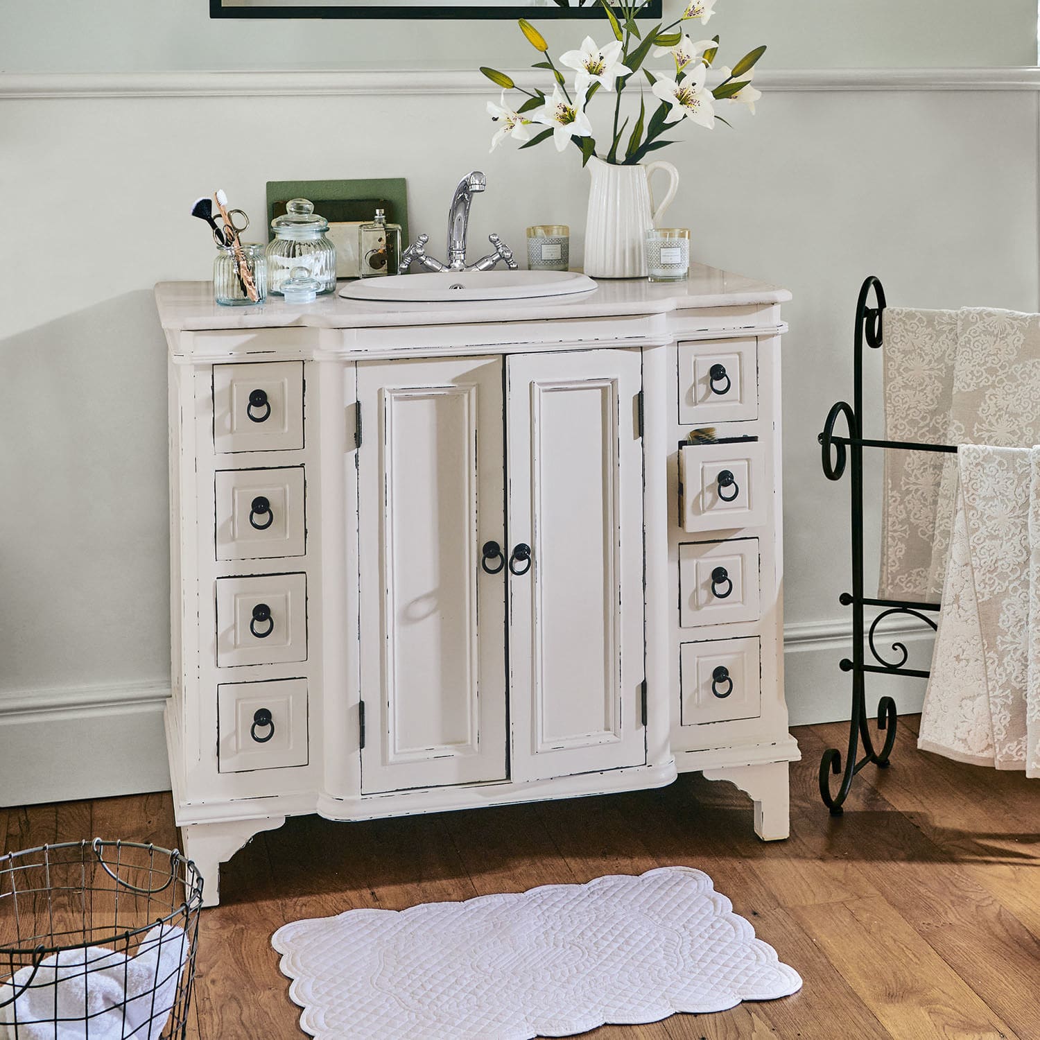 Meuble avec vasque Sunderland Meuble de salle de bain en bois blanc avec lavabo et poignées métalliques sur sol en bois