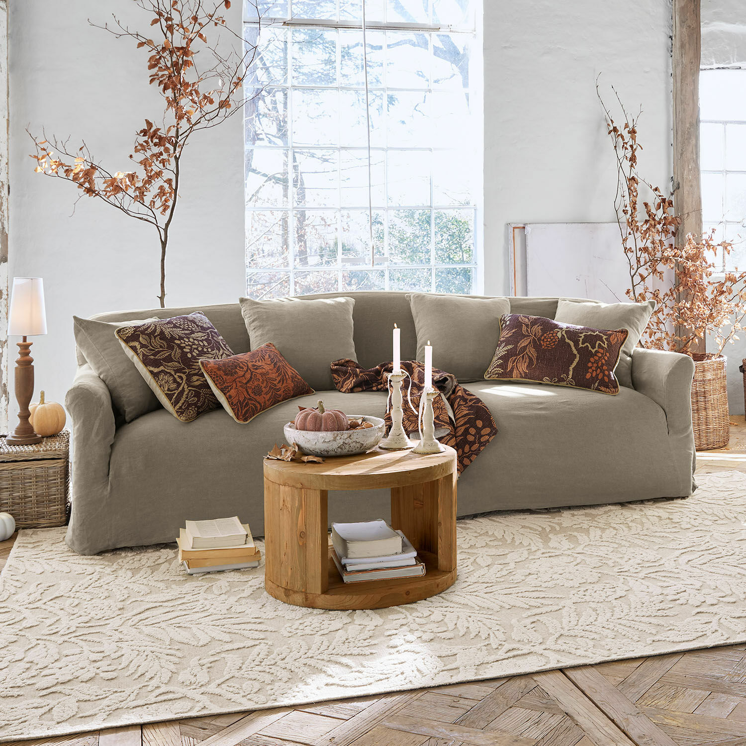 Canapé Riveneuve Canapé beige en tissu dans un salon lumineux avec table basse en bois et décorations d'automne