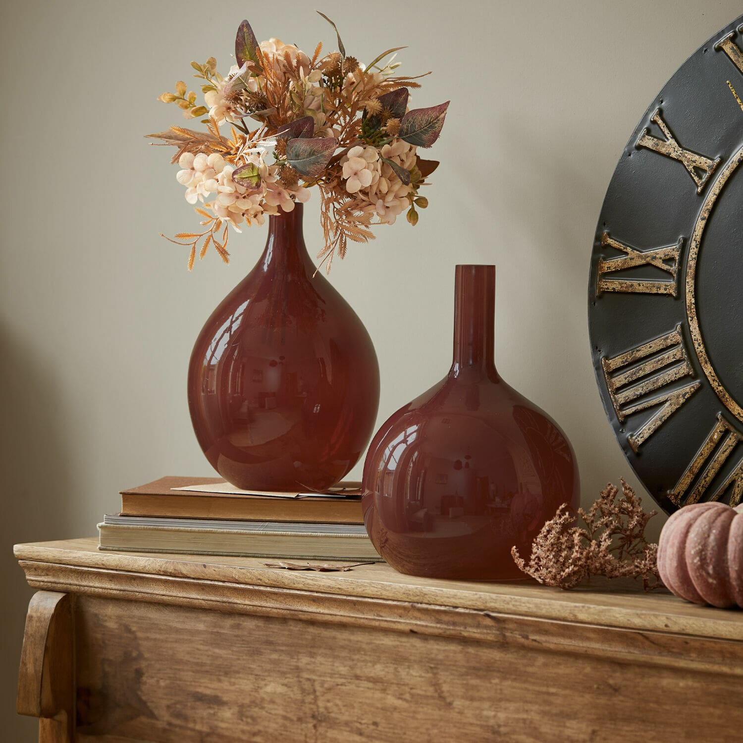 Lot de 2 vases Erlunda Deux vases en verre marron sur une table en bois avec fleurs séchées décoratives et livres