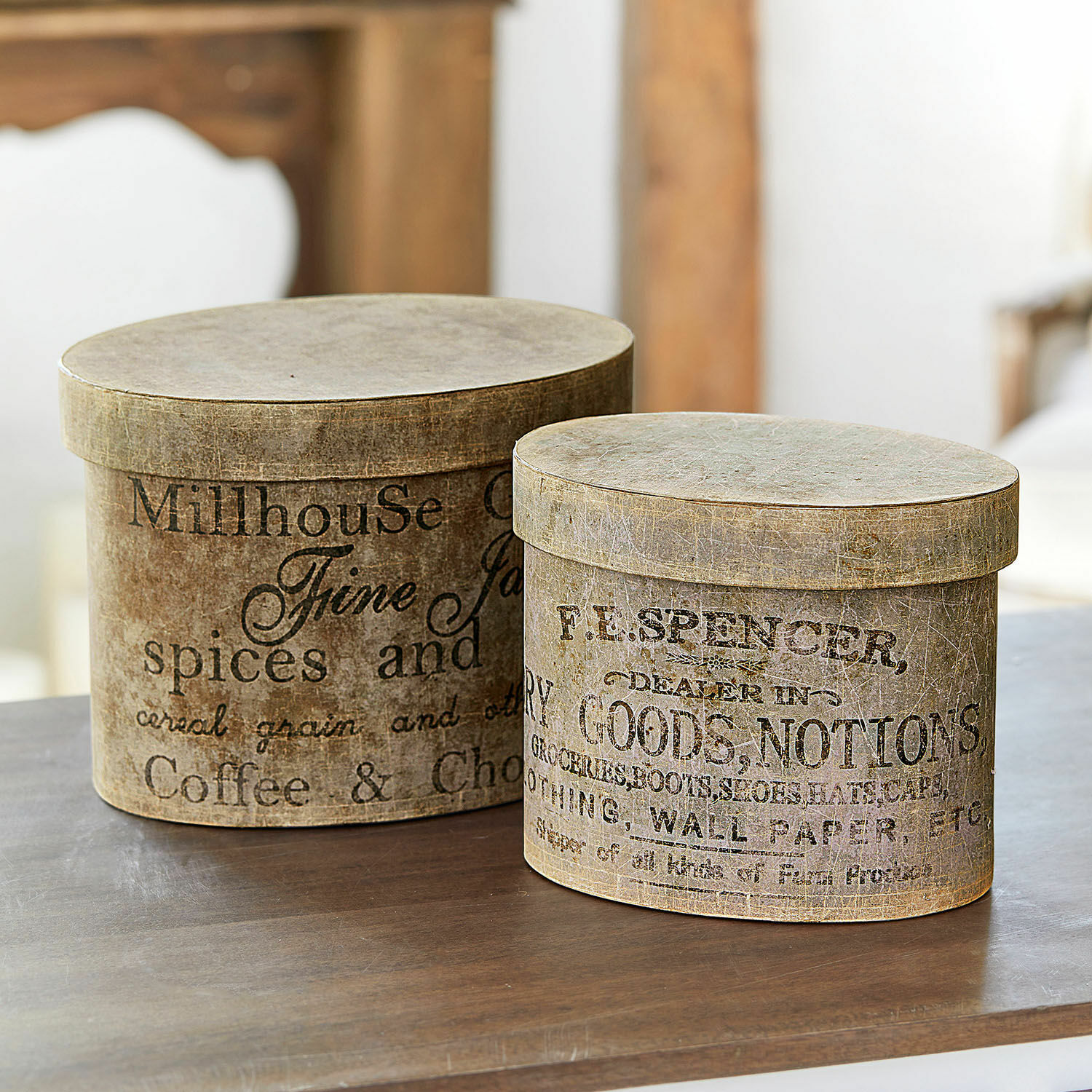 Lot de 2 boîtes Tunguska Deux boîtes rondes décoratives marron avec impression vintage posées sur une table en bois