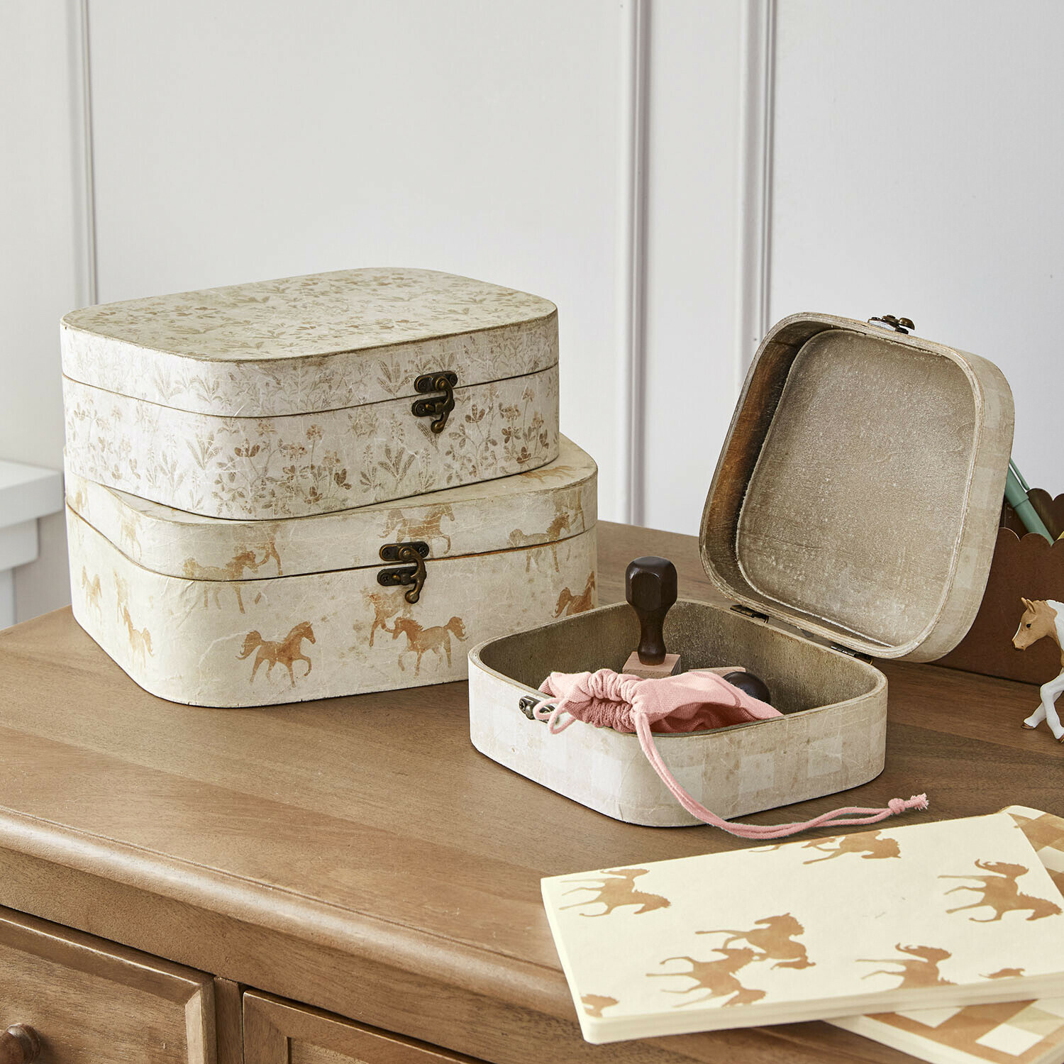 Lot de 3 boîtes Windermay Ensemble de trois boîtes décoratives en papier beige avec motifs de chevaux et fleurs sur un meuble en bois