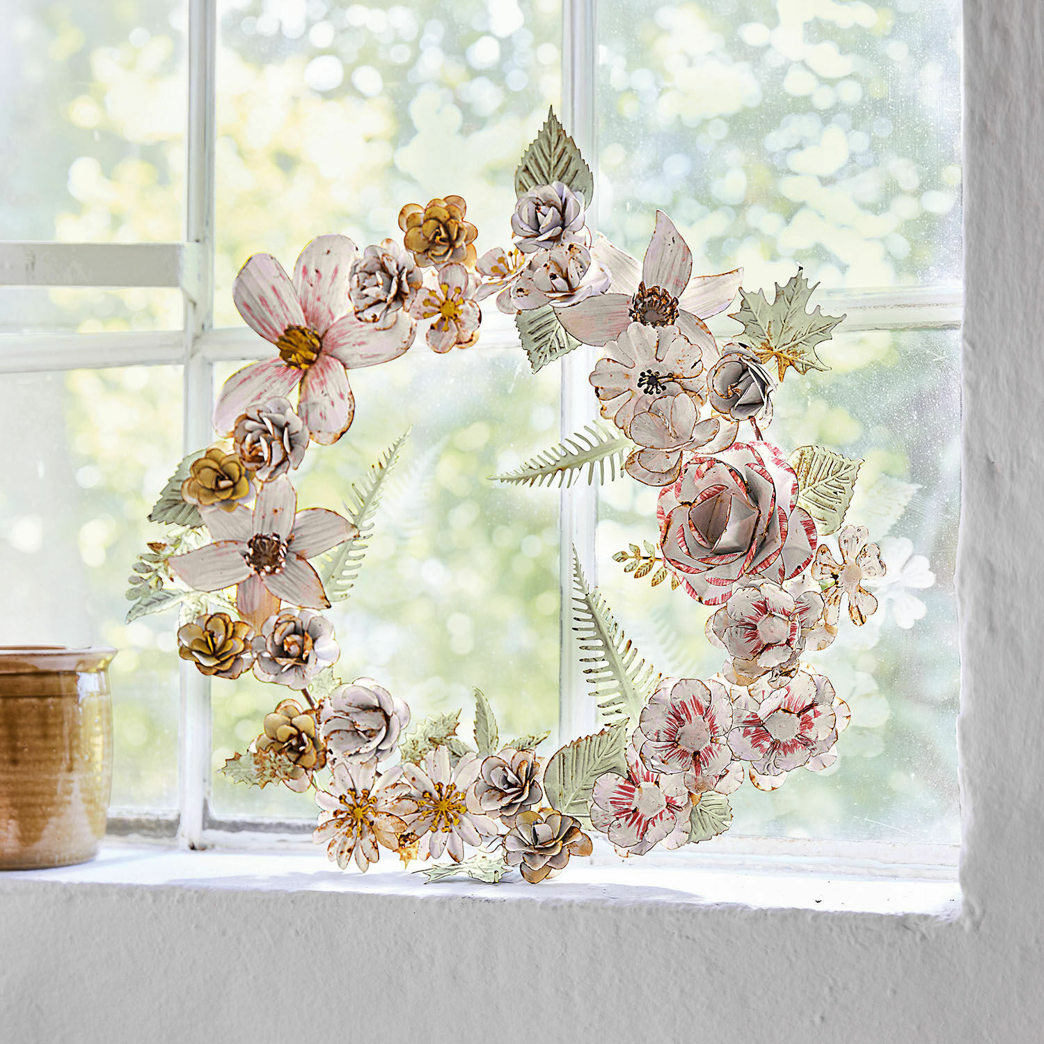 Couronne Jesse Couronne décorative en fleurs métalliques pastel posée sur une fenêtre, décoration intérieure