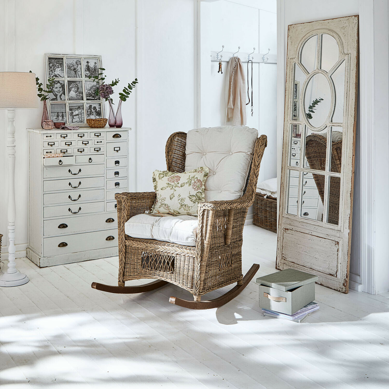 Fauteuil à bascule Jeveren Fauteuil à bascule en rotin avec coussins crème dans un intérieur lumineux au sol blanc