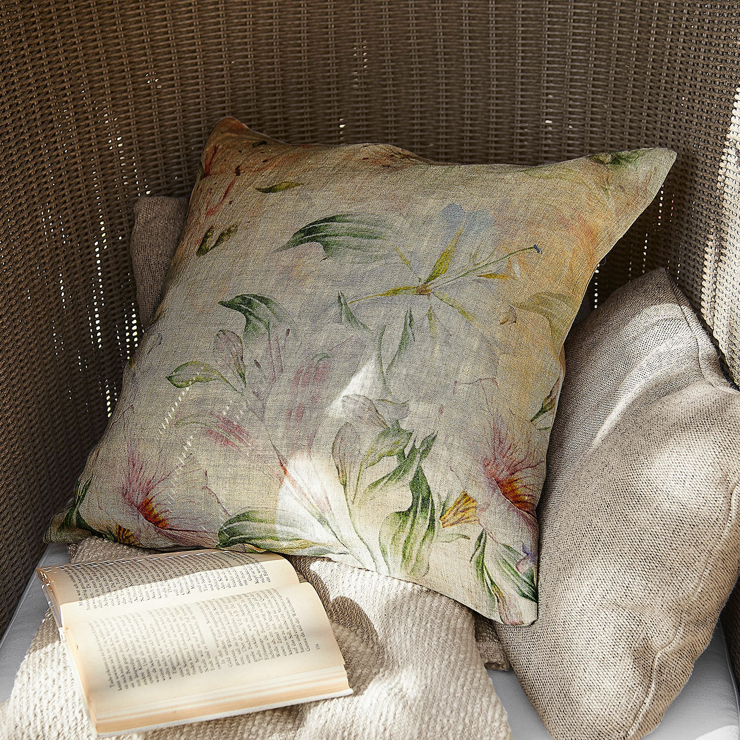 Housse de coussin Florevin Coussin décoratif en lin à motif floral aux couleurs naturelles sur fauteuil en osier