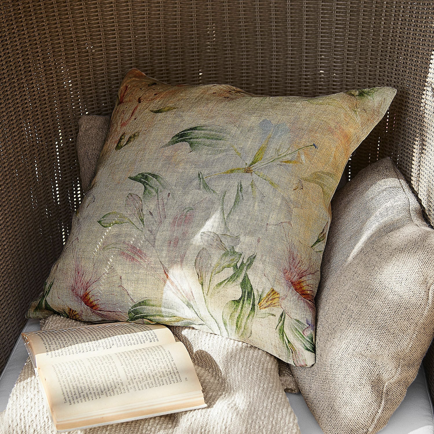 Housse de coussin Florevin Coussin décoratif en lin à motif floral aux couleurs naturelles sur fauteuil en osier