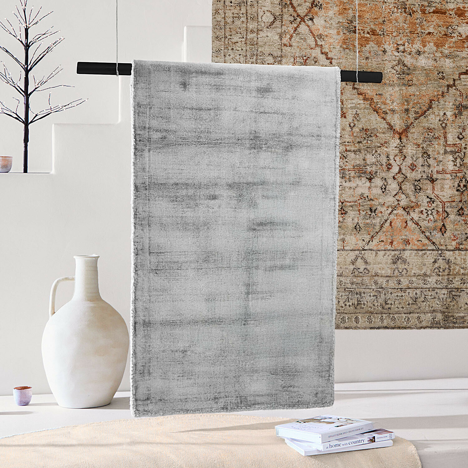 Tapis Mariselle Tapis gris en tissu doux suspendu dans un intérieur moderne avec vase décoratif et livres