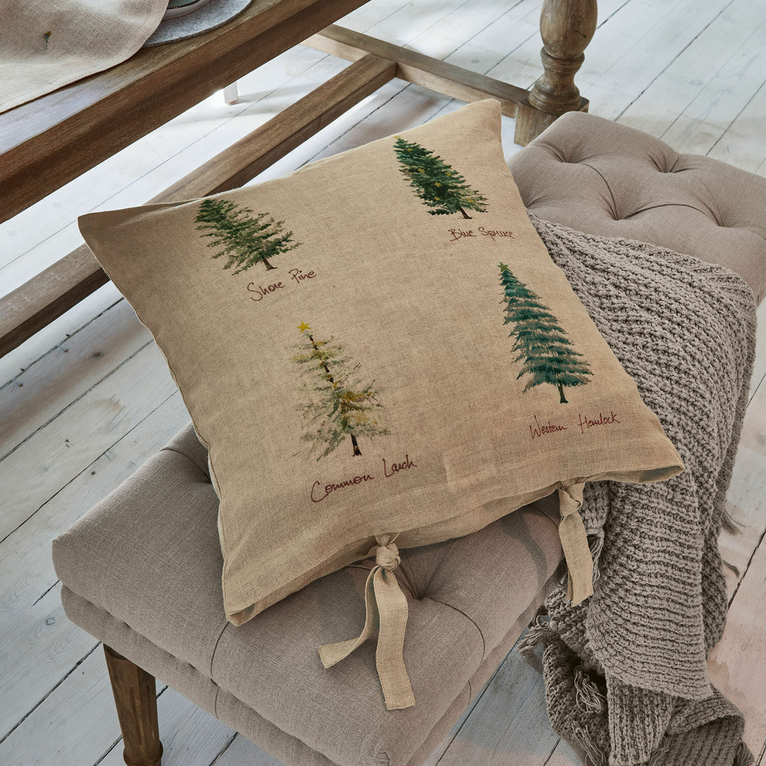 Housse de coussin Jarrier Coussin beige en lin avec imprimé d'arbres et liens noués sur un siège gris