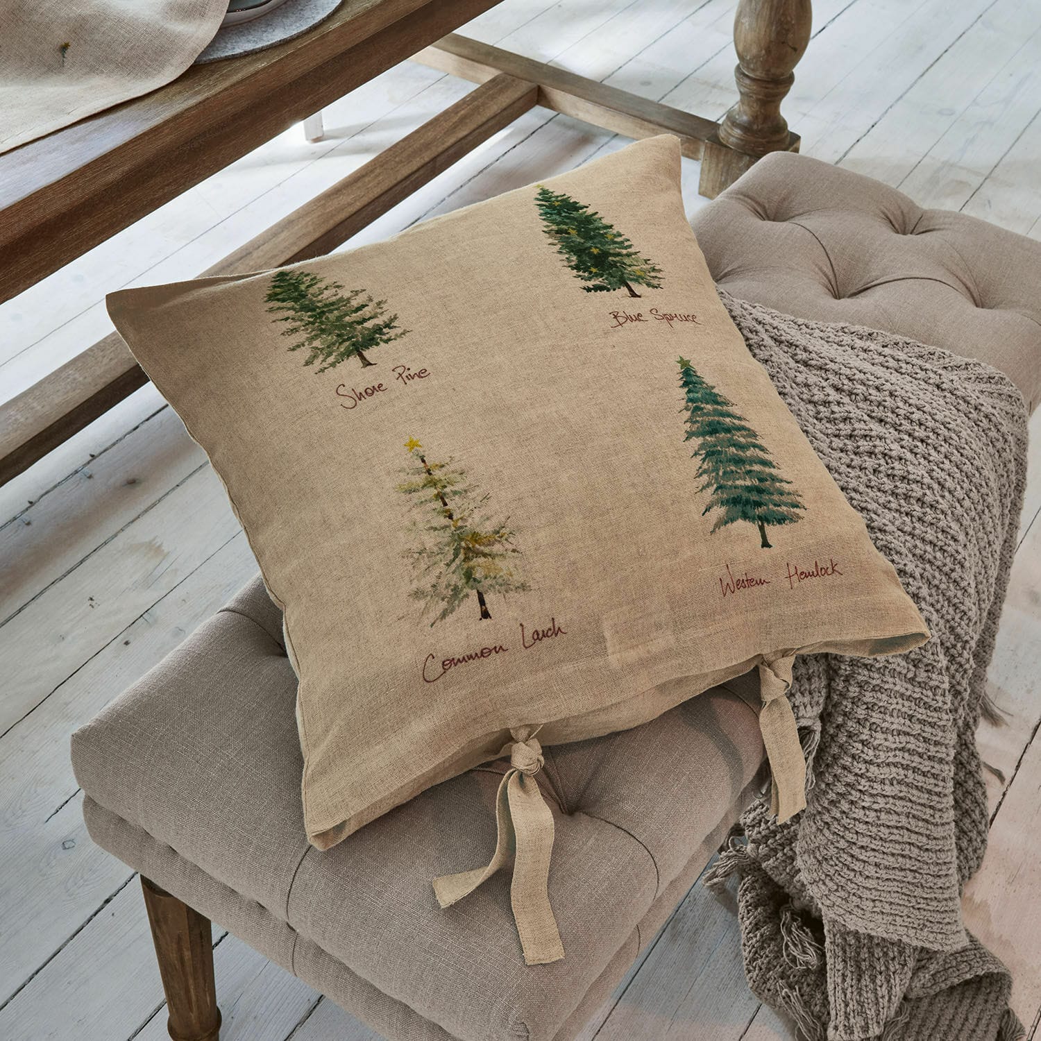 Housse de coussin Jarrier Coussin beige en lin avec imprimé d'arbres et liens noués sur un siège gris