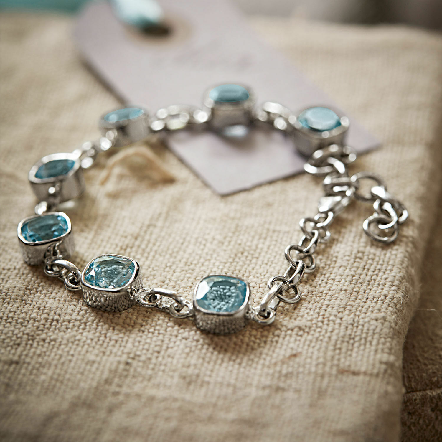 Bracelet Lilianne Bracelet en argent avec pierres bleues sur tissu beige, bijou élégant pour femme