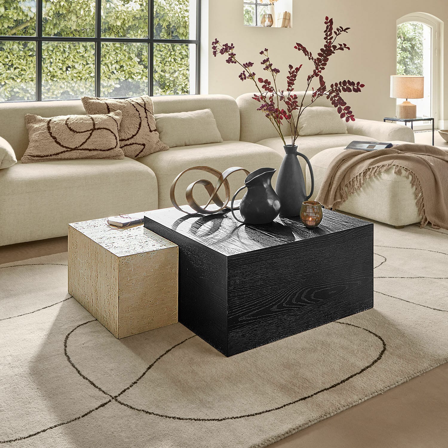 Table basse Caleneuve Salon moderne avec canapé beige et deux tables basses en bois et pierre, décorations sur la table