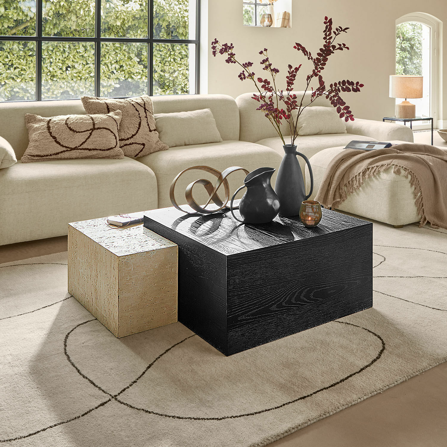 Table basse Caleneuve Salon moderne avec canapé beige et deux tables basses en bois et pierre, décorations sur la table