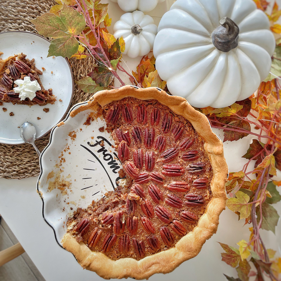 Tarte aux noix de pécan sur assiette avec décoration d'automne et citrouilles blanches