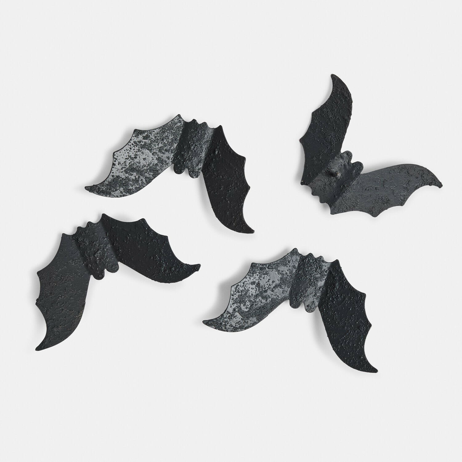 Lot de 4 pin’s décoratifs Brynnach Quatre décorations murales en métal noir en forme de chauves-souris avec texture rugueuse sur fond blanc