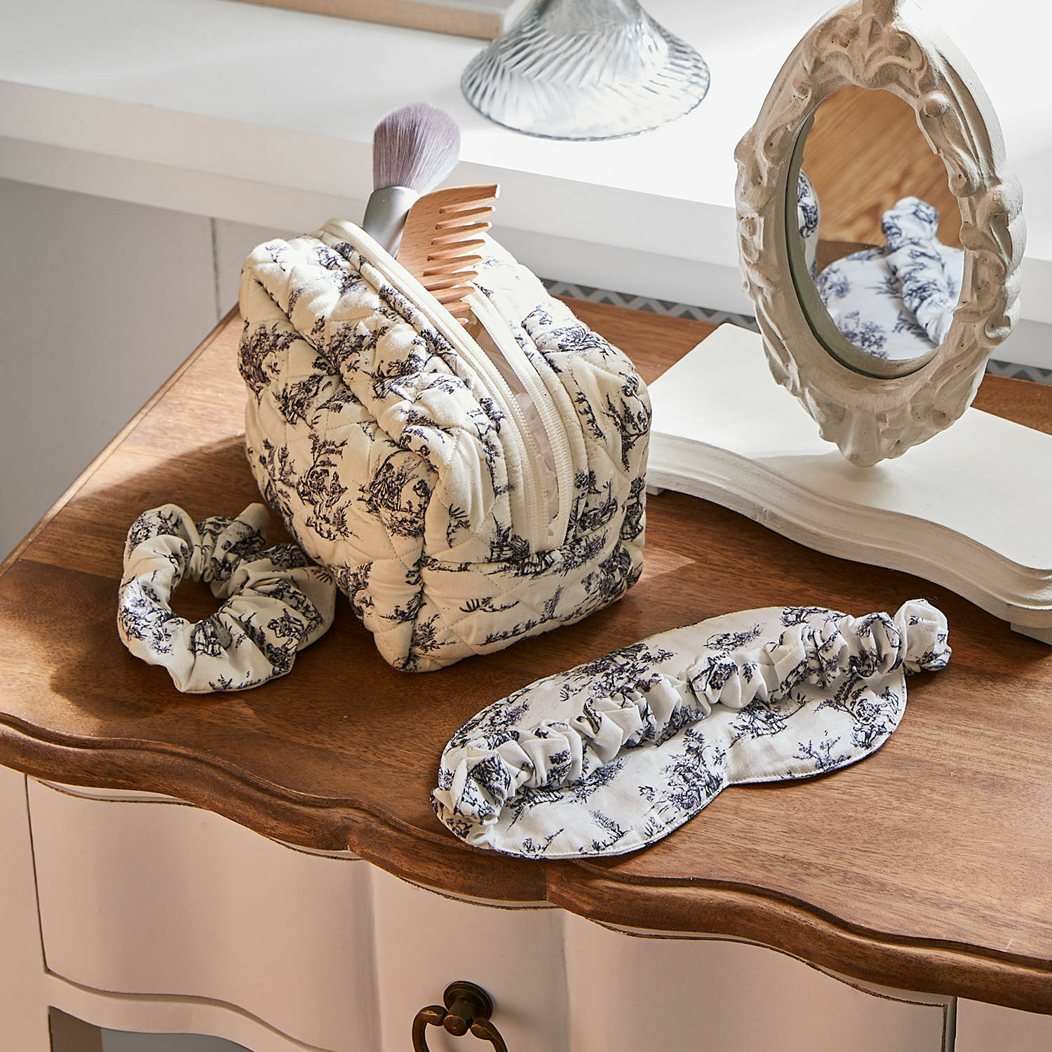 Kit sommeil 3 pièces Felencio Trousse de toilette matelassée beige à motif noir avec bandeau et masque de sommeil sur table en bois, accessoires beauté