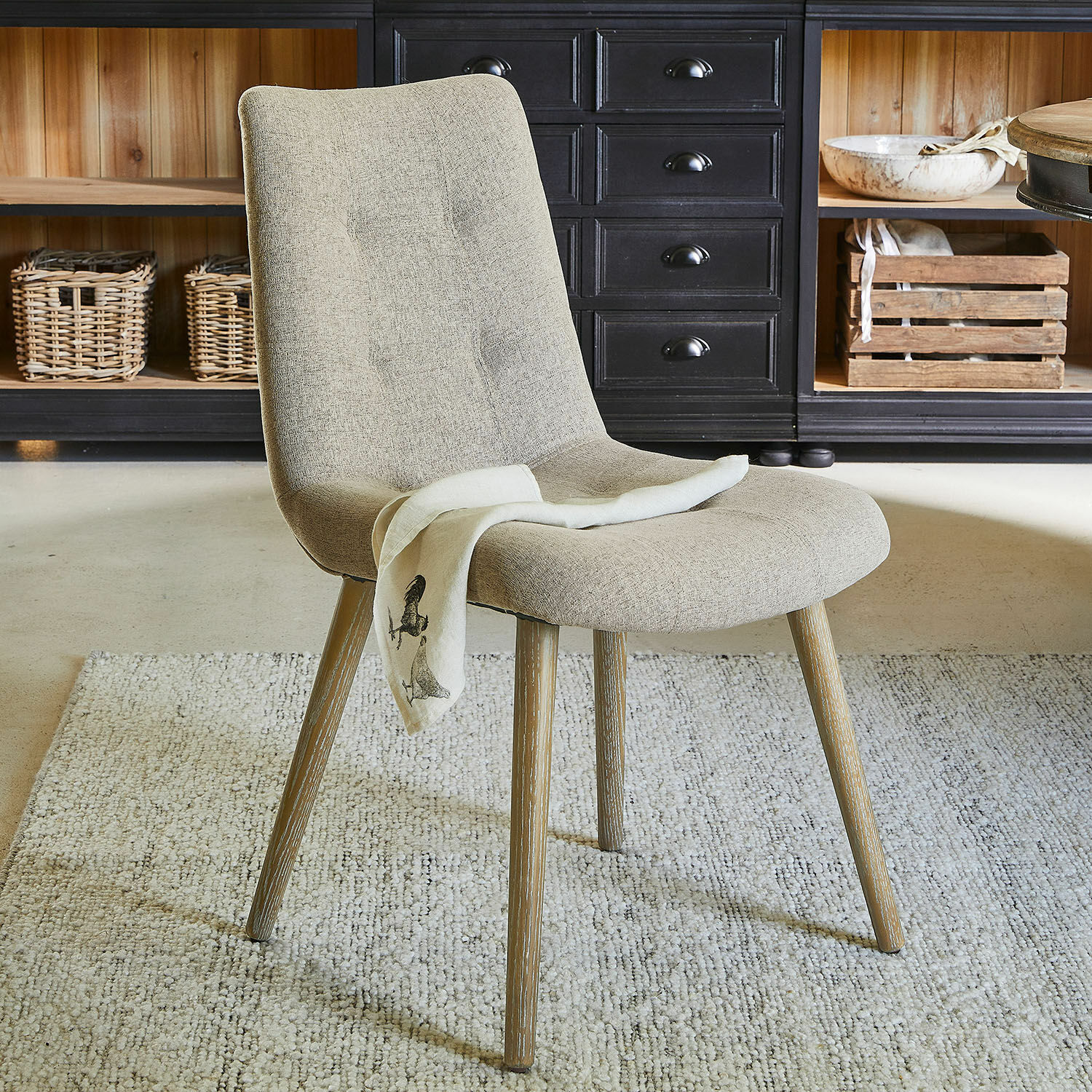 Chaise Vietri Chaise beige rembourrée avec pieds en bois sur tapis dans un intérieur moderne
