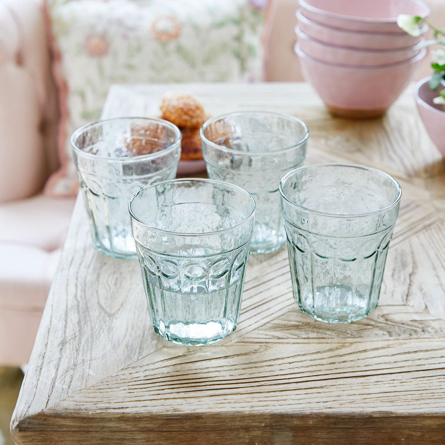 Lot de 4 verres Alizande Ensemble de quatre verres transparents texturés sur une table en bois pour boissons