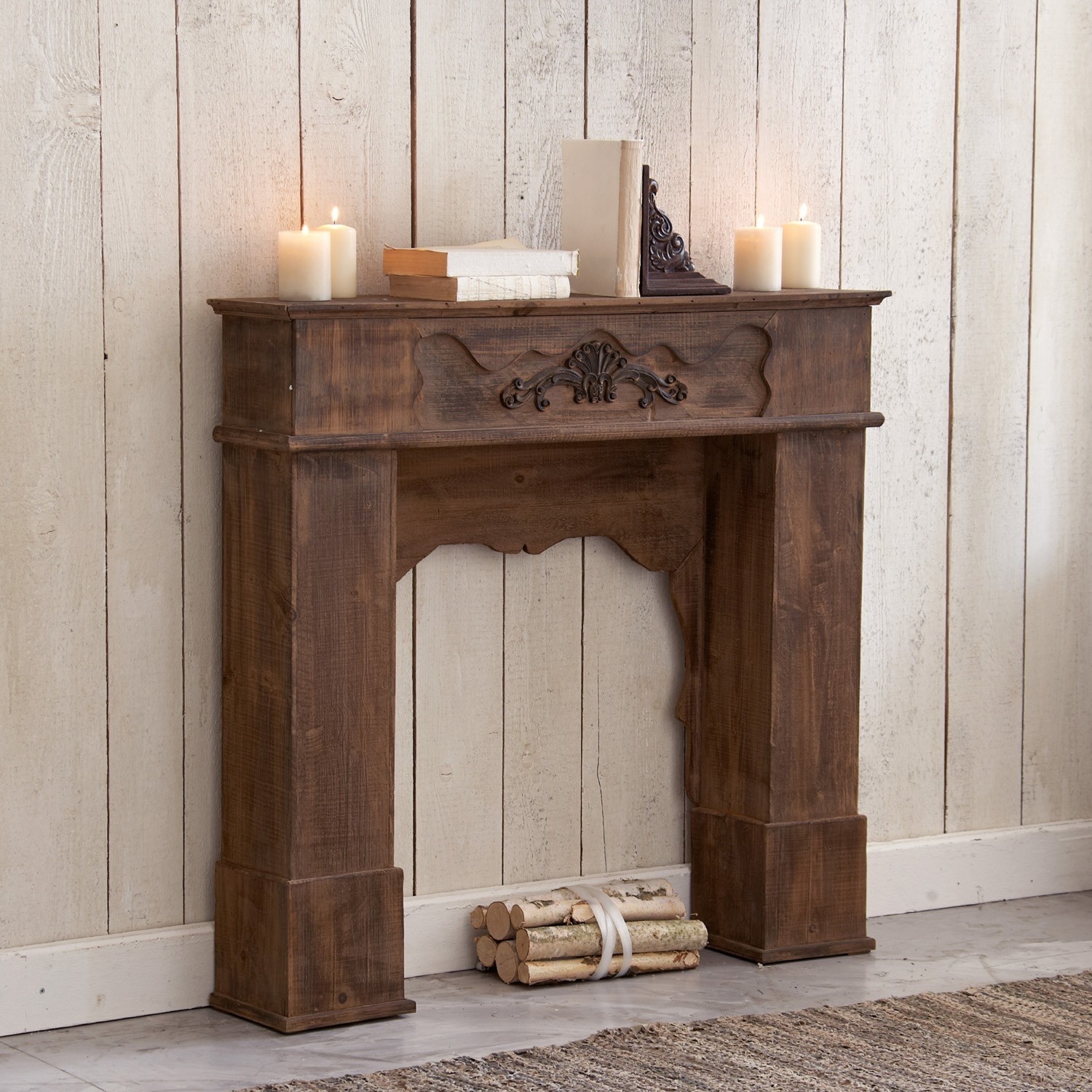 Manteau de cheminée Margaux Cheminée décorative en bois foncé avec motif sculpté, décorée de bougies et livres