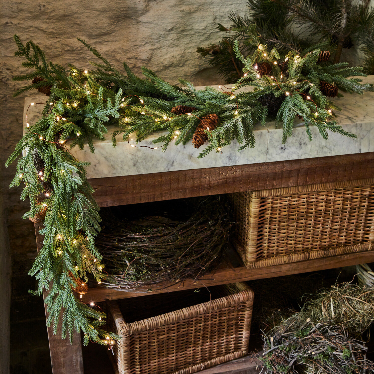 Guirlande LED Sahani Guirlande décorative en branches vertes et pommes de pin avec éclairage LED sur une table en bois