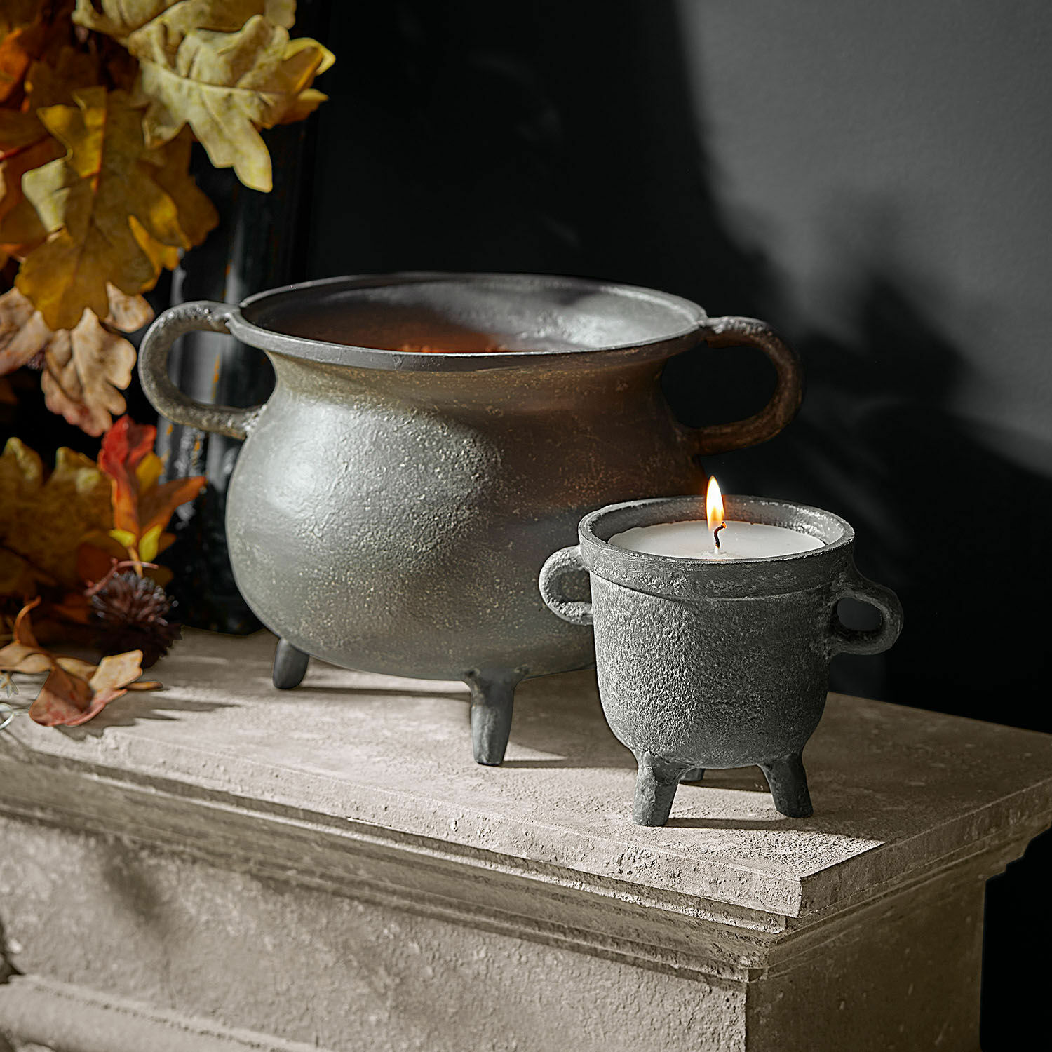 Lot de 2 photophores avec bougies Lavignoux Bougeoir et coupe décoratifs en métal gris posés sur un rebord en pierre avec feuilles d'automne