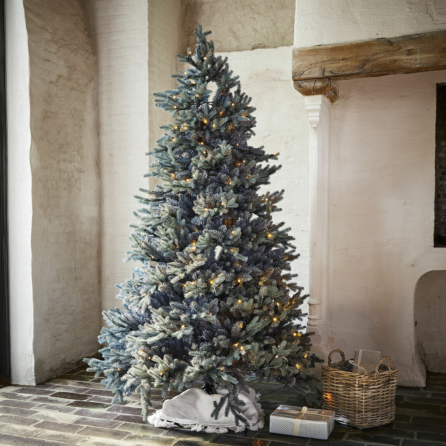 Sapin de Noël Patrick Sapin artificiel aux branches enneigées avec lumières LED chaudes dans un intérieur rustique