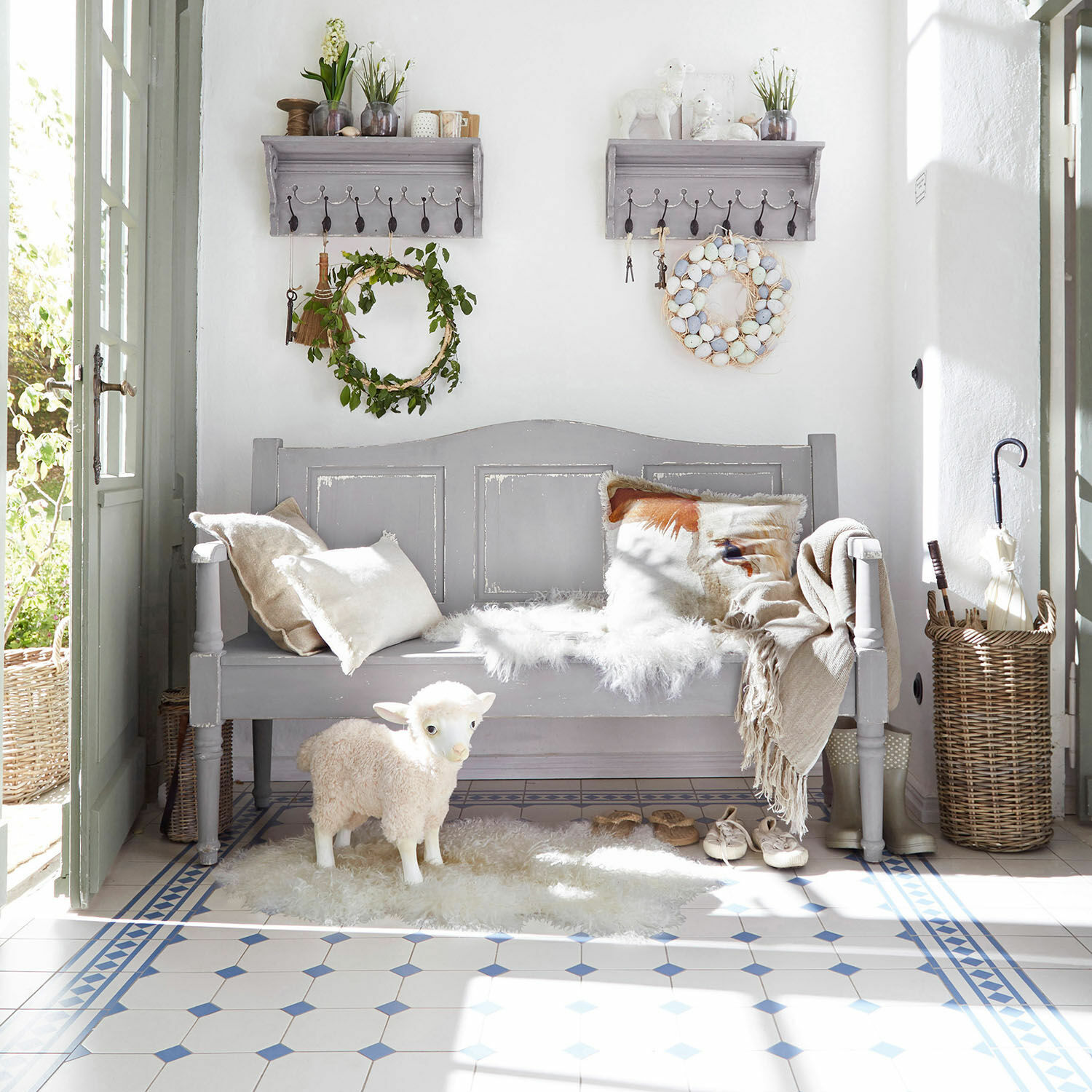 Banc Lynnfield Banc en bois gris avec coussins et figurine de mouton décorative sur sol carrelé clair