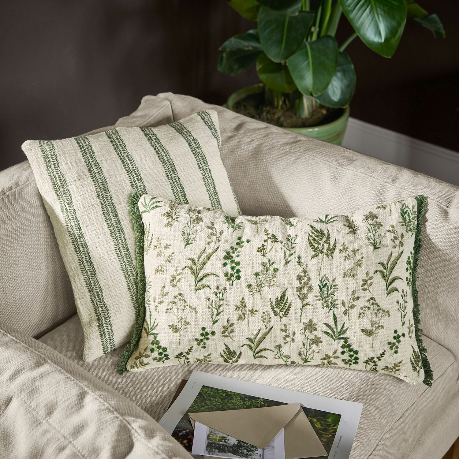 Lot de 2 housses de coussin Wescombe Coussins décoratifs réversibles en coton avec motifs végétaux verts et rayures sur canapé beige