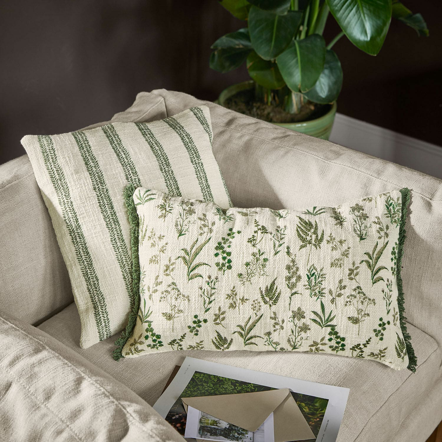 Lot de 2 housses de coussin Wescombe Coussins décoratifs réversibles en coton avec motifs végétaux verts et rayures sur canapé beige