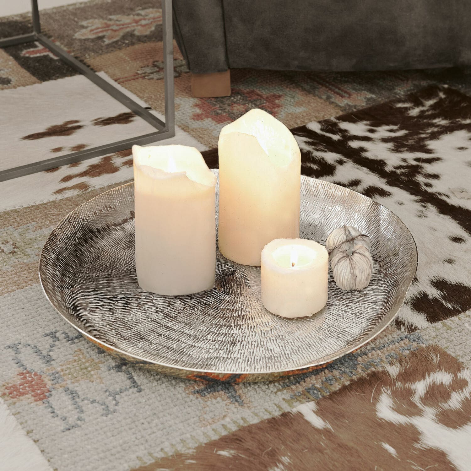 Plateau Caelan Plateau décoratif argenté avec trois bougies blanches sur un tapis à motif animalier