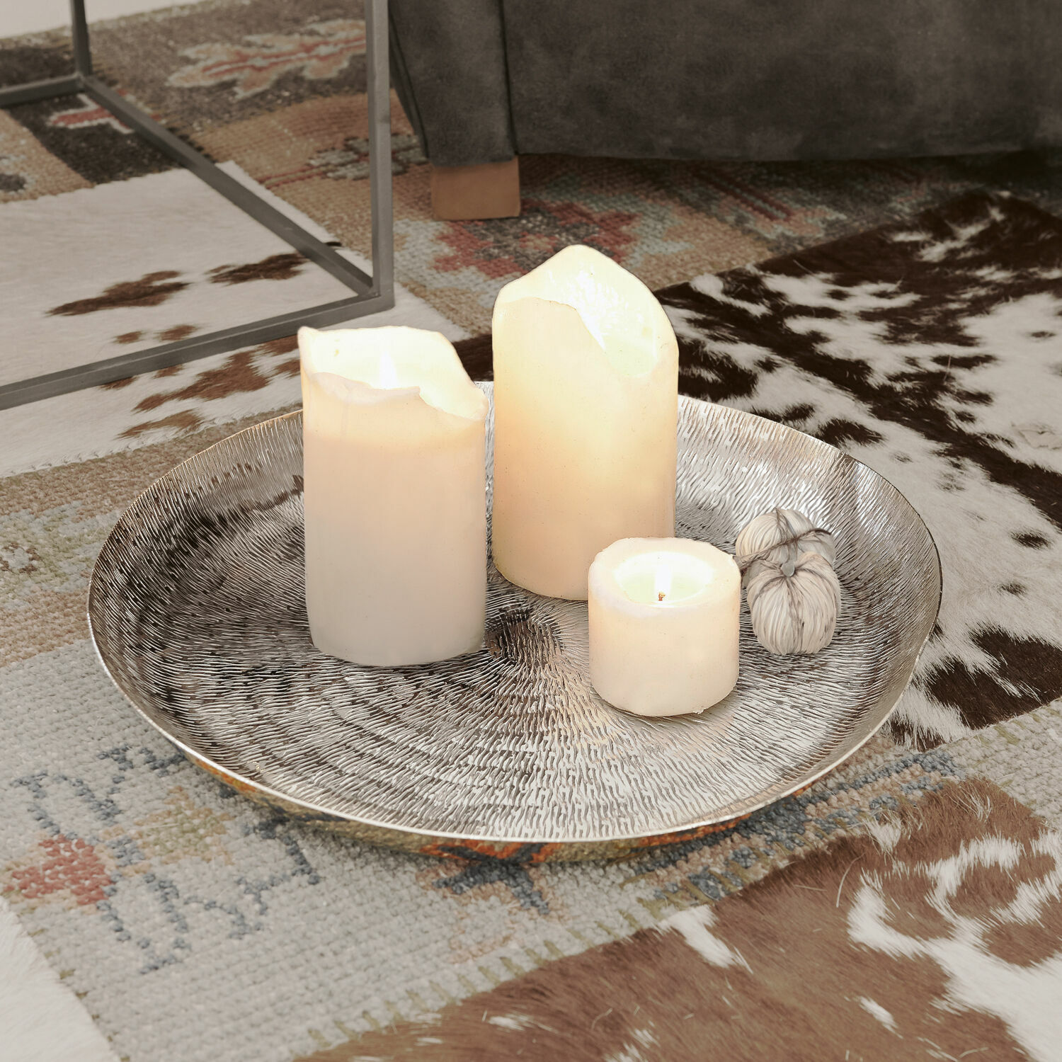 Plateau Caelan Plateau décoratif argenté avec trois bougies blanches sur un tapis à motif animalier