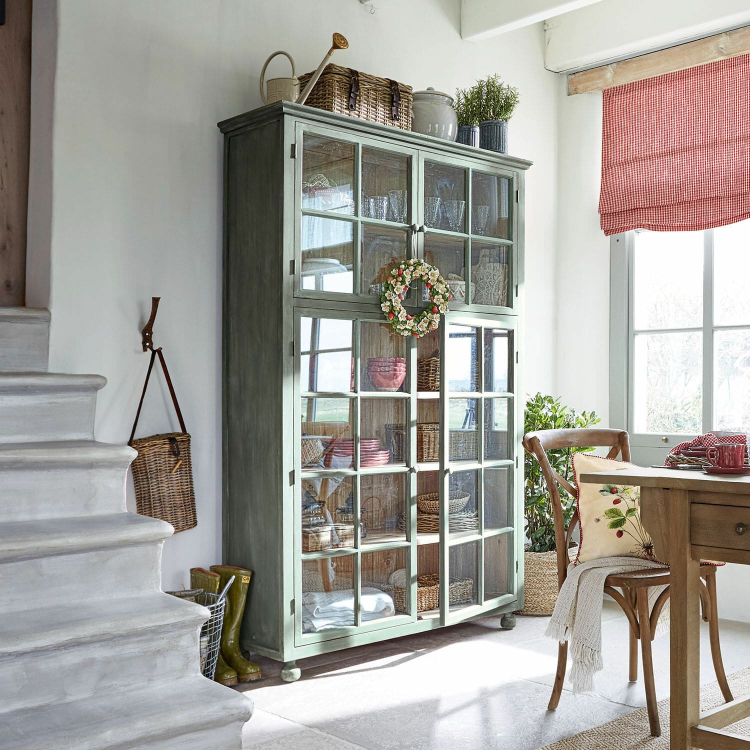 Vaisselier Bellac Vitrine en bois vert avec portes vitrées dans un salon lumineux décoré naturellement