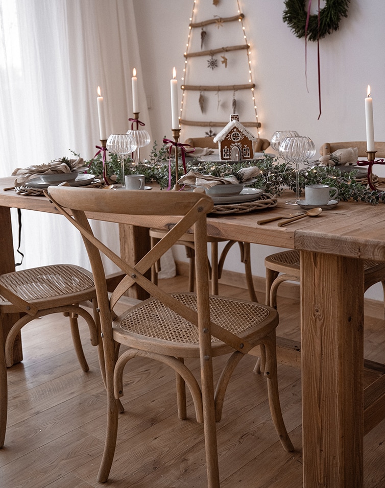 Table en bois naturel avec chaises assorties, décoration de Noël avec maison en pain d'épices et bougies