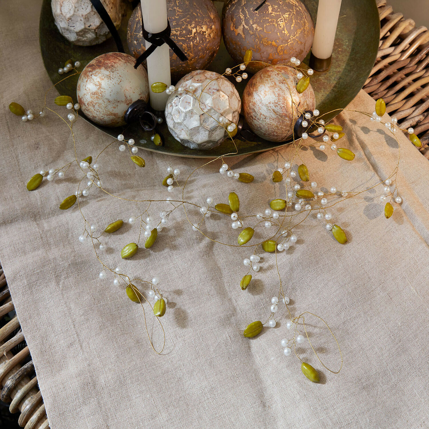 Guirlande Kelira Guirlande décorative avec perles vertes et blanches sur nappe en lin avec boules décoratives
