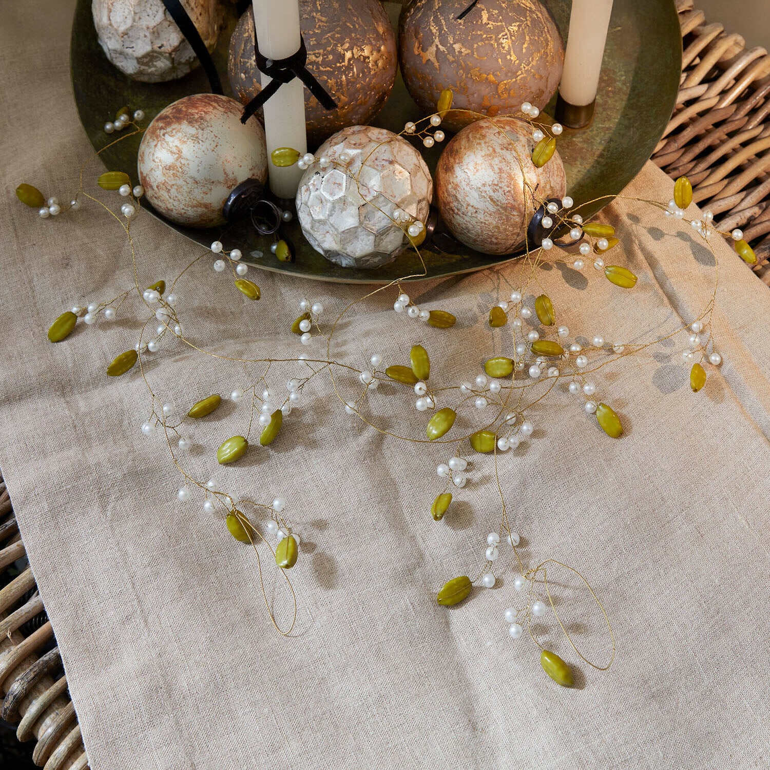 Guirlande Kelira Guirlande décorative avec perles vertes et blanches sur nappe en lin avec boules décoratives