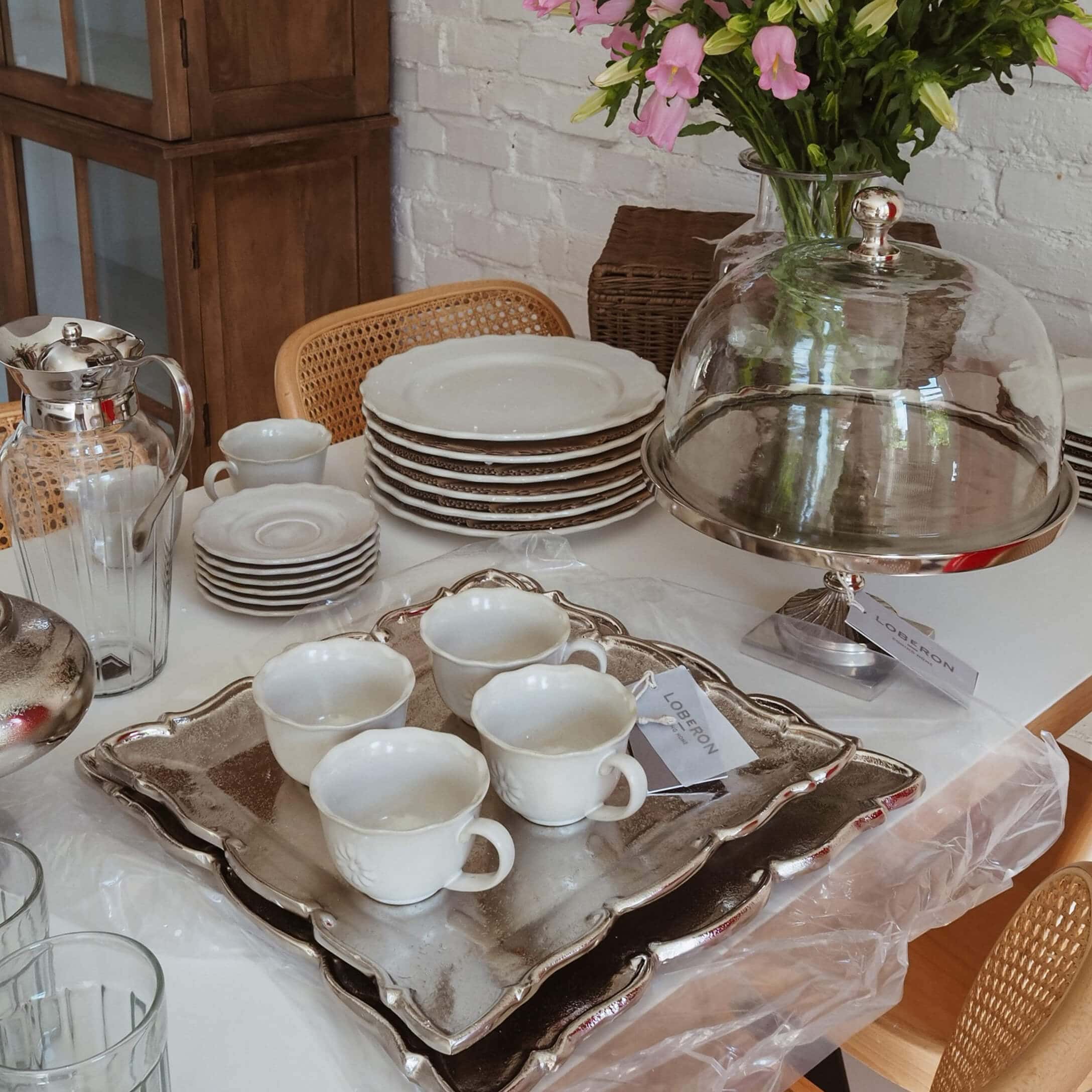 Service en porcelaine blanche avec tasses et assiettes sur plateau argenté, décoration de table slow living