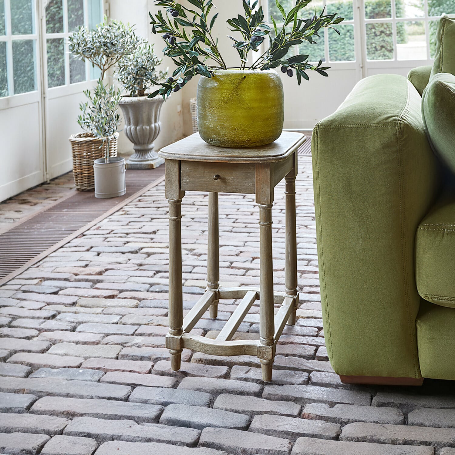 Table d'appoint Jaxeno Table d'appoint en bois style vintage avec tiroir et vase décoratif vert sur sol en briques