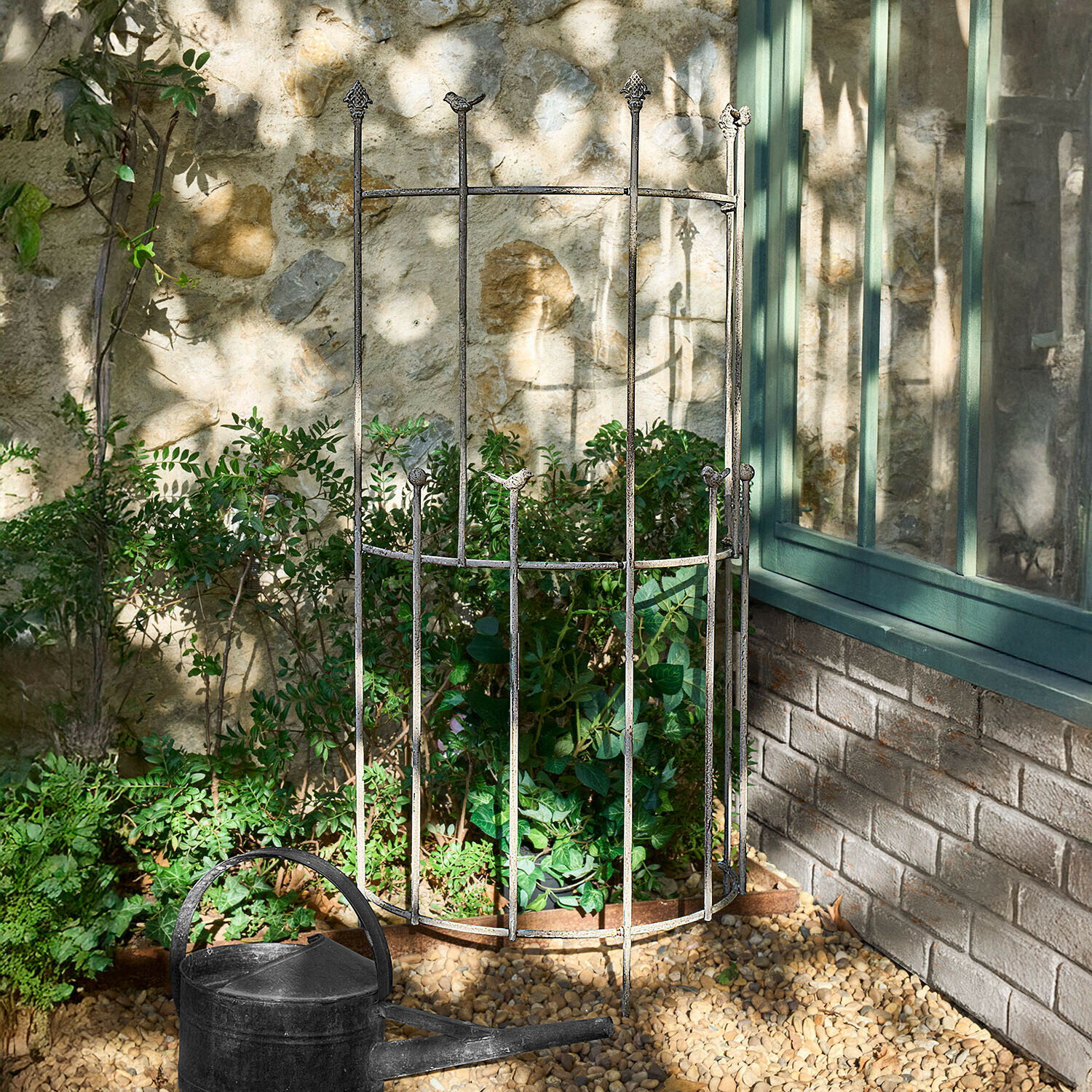 Treillage Ormisse Protection de plante en métal vieilli avec décor d'oiseaux dans un jardin ensoleillé