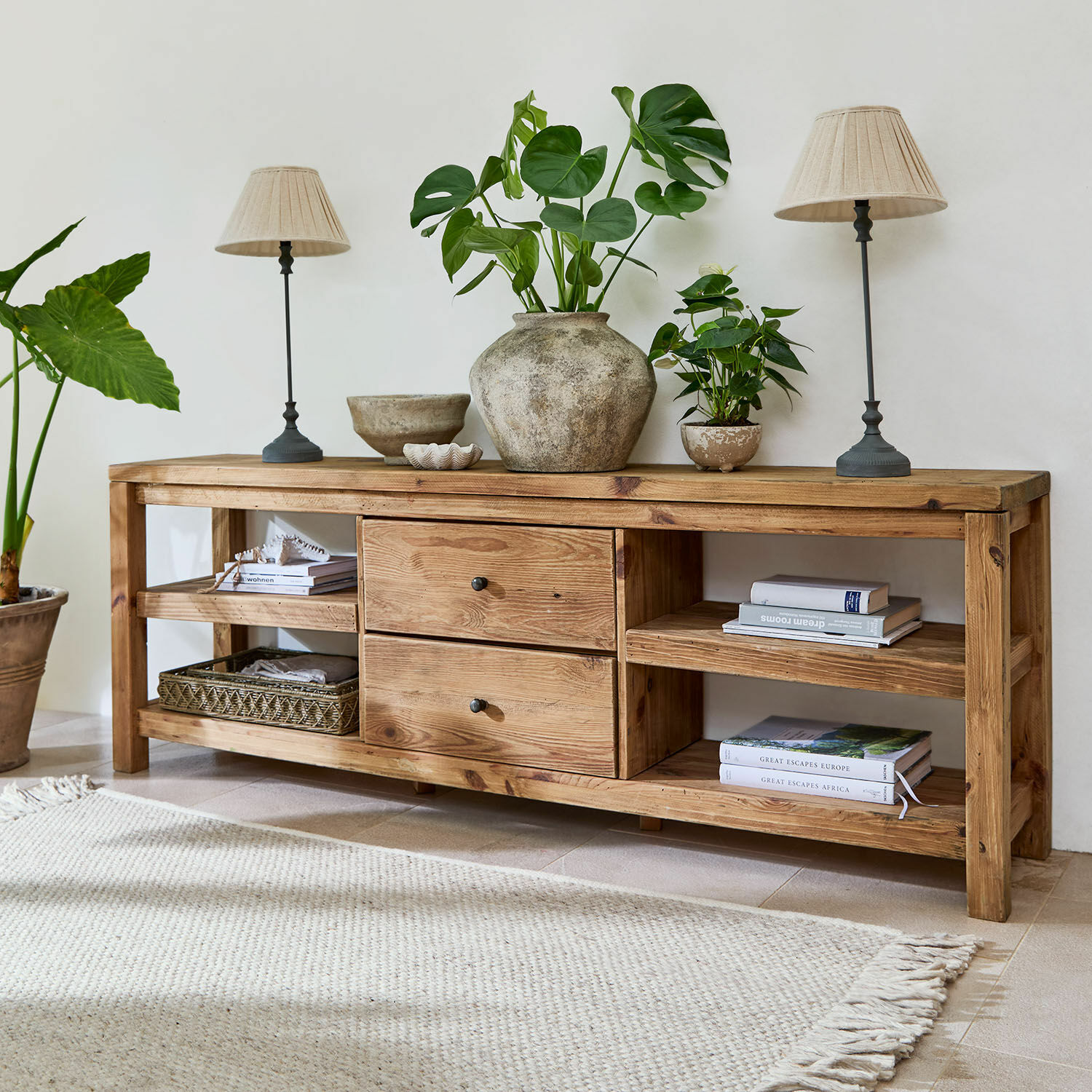 Buffet bas Ainvelle Console en bois naturel avec tiroirs et étagères, décorée de plantes vertes et lampes beiges