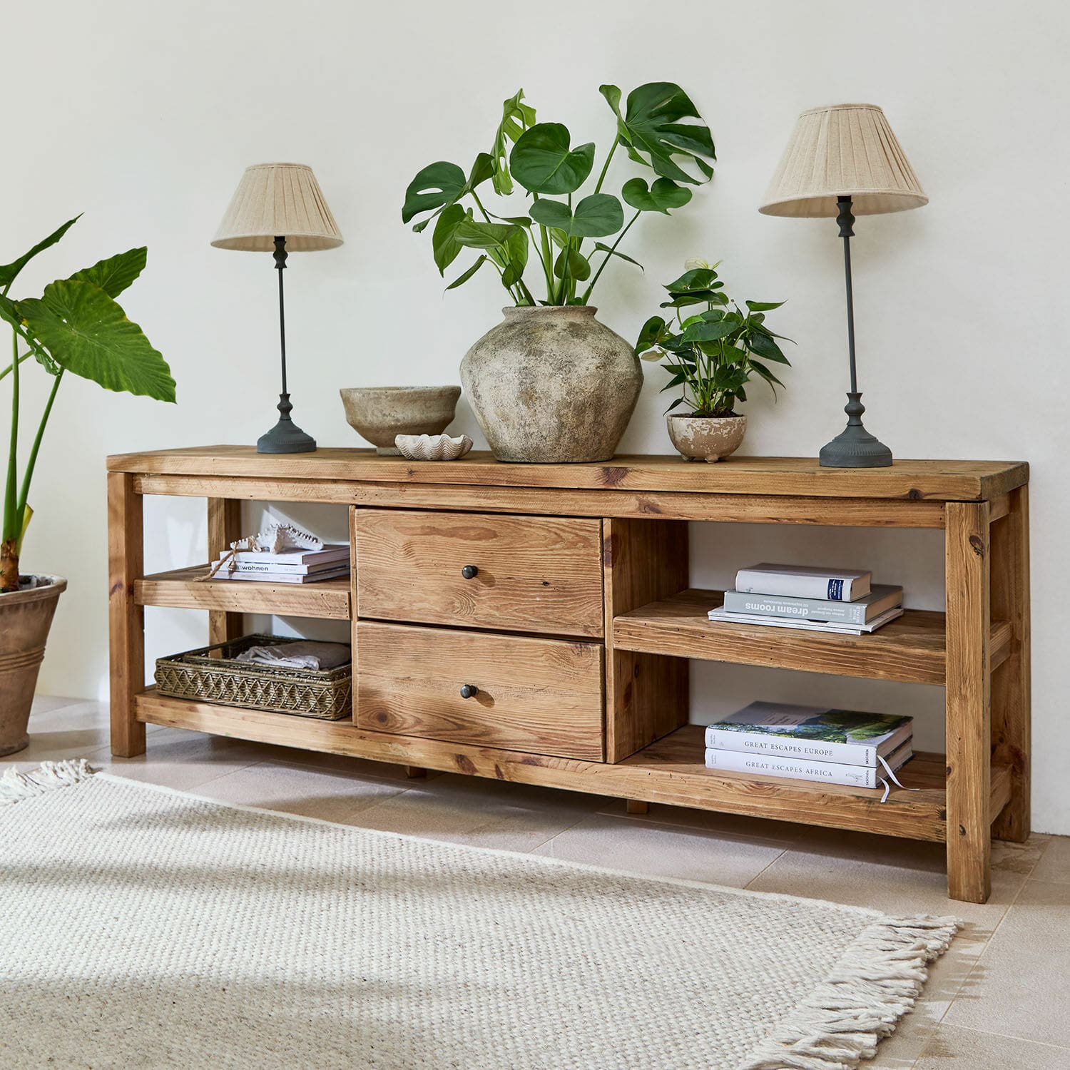 Buffet bas Ainvelle Console en bois naturel avec tiroirs et étagères, décorée de plantes vertes et lampes beiges