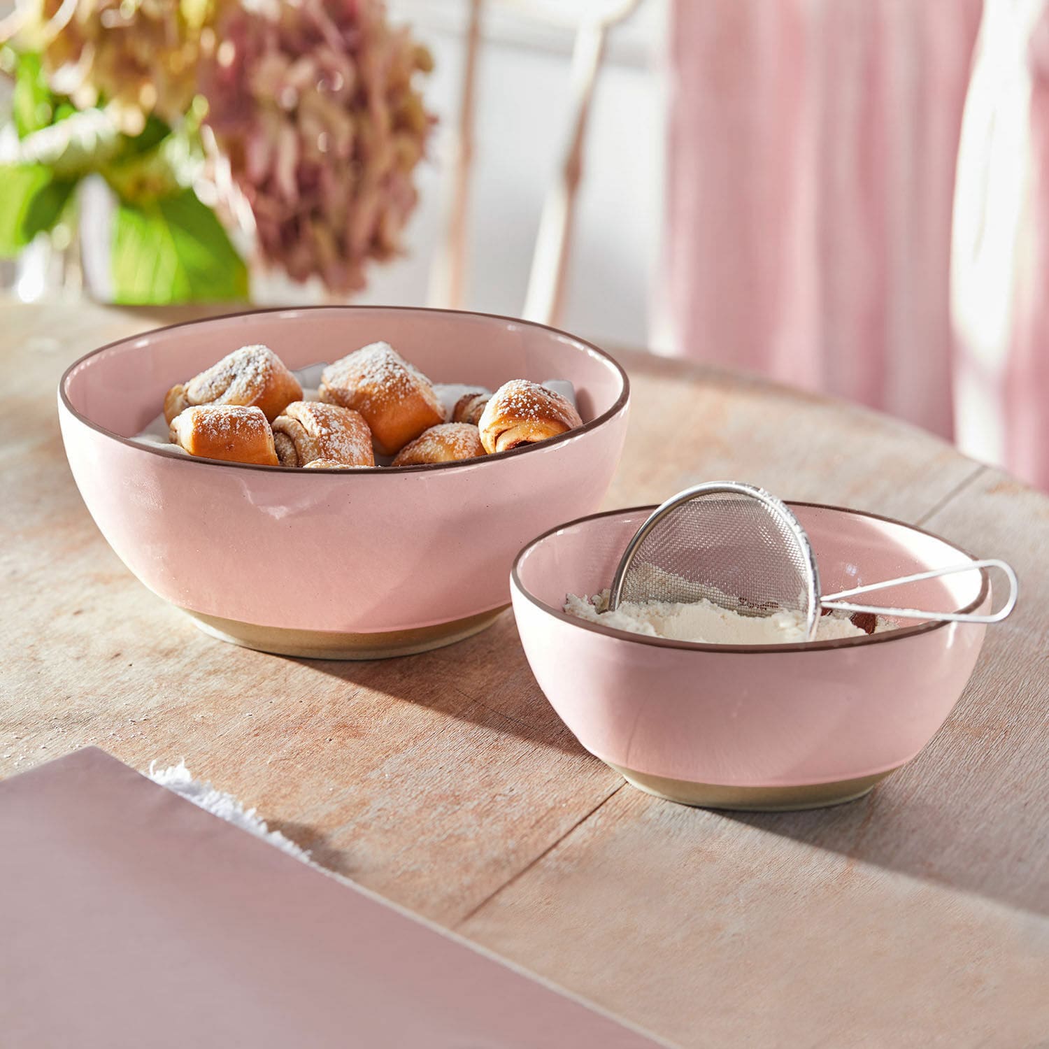 Lot de 2 saladiers Biarré Bols en céramique rose contenant des pâtisseries et de la farine sur une table en bois