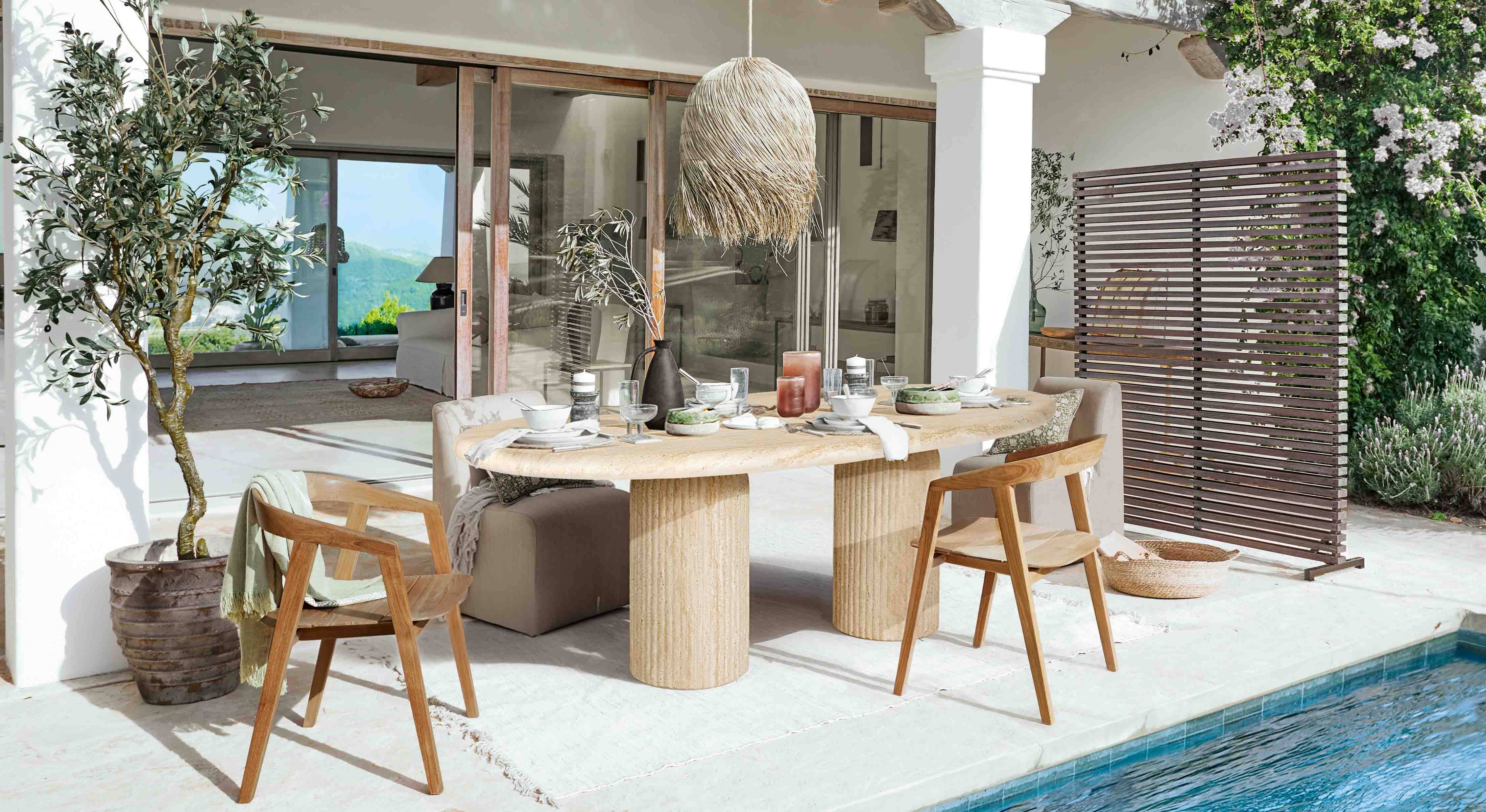 Salle à manger extérieure avec table en pierre et chaises en bois près de la piscine dans un style naturel