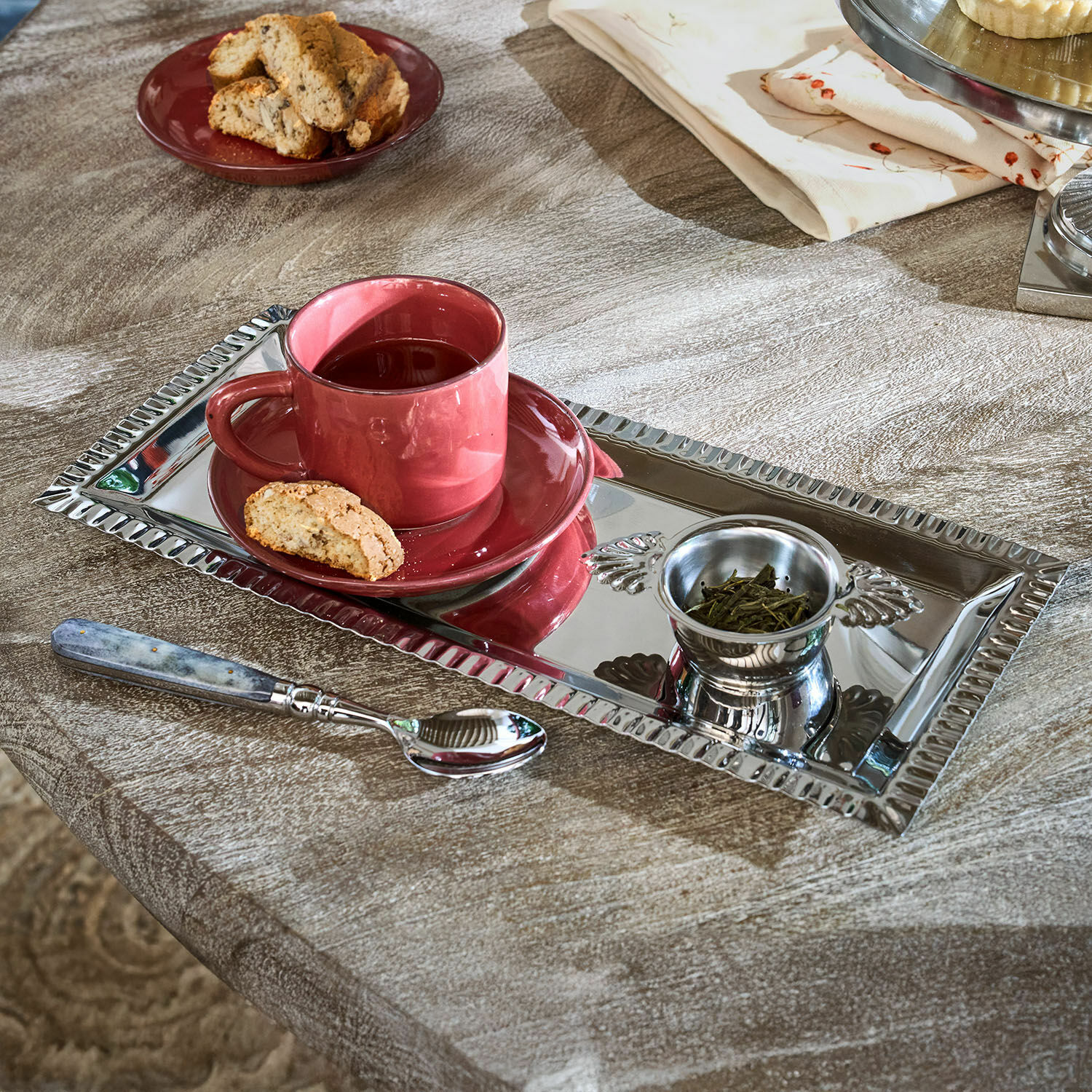 Ensemble à thé Arivelle Plateau rectangulaire en métal argenté avec tasse rouge, thé et biscuit sur table en bois