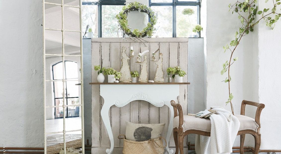 Console blanche avec décorations et plantes vertes dans un intérieur lumineux et rustique