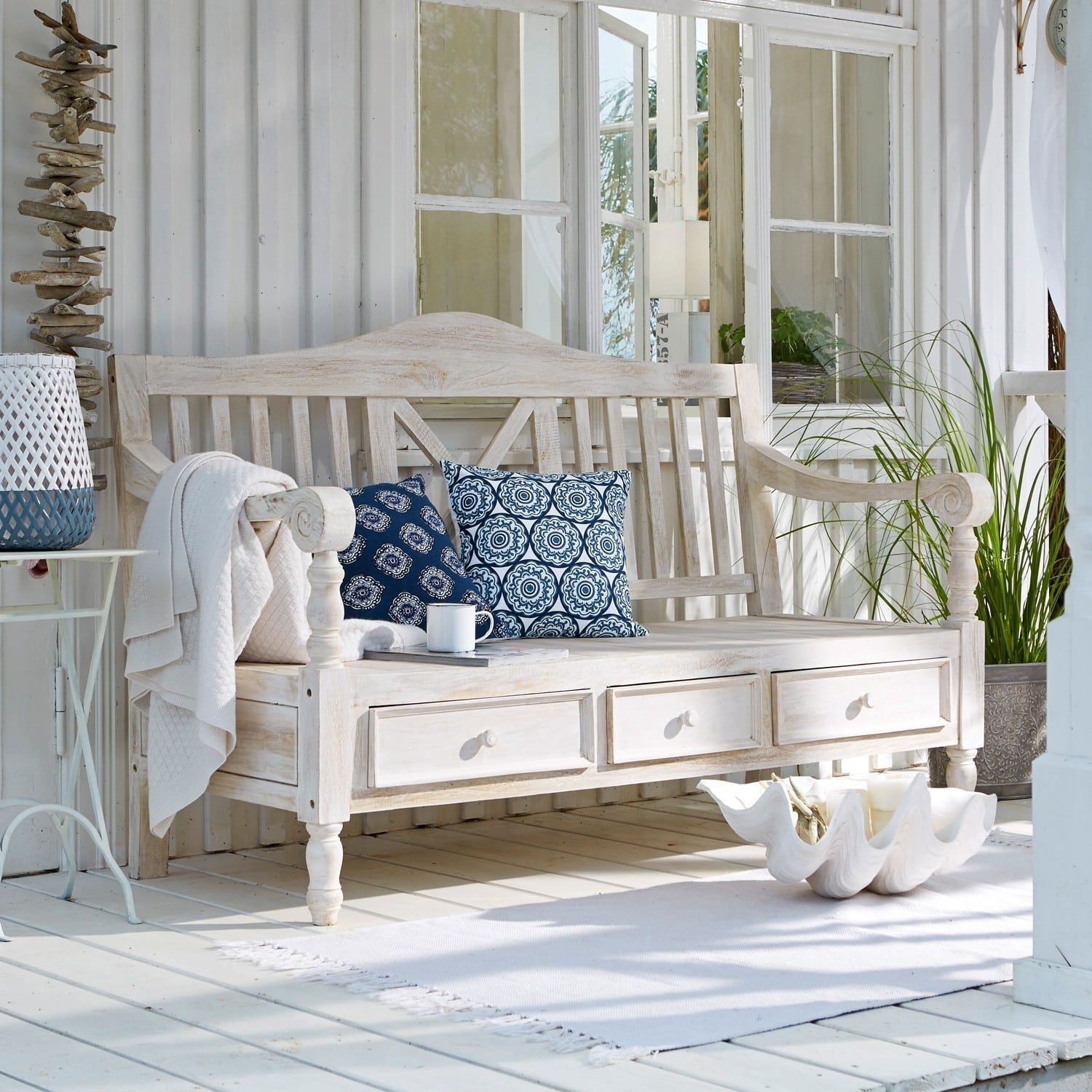 Banc en bois blanc avec trois tiroirs et coussins bleus dans un style vintage