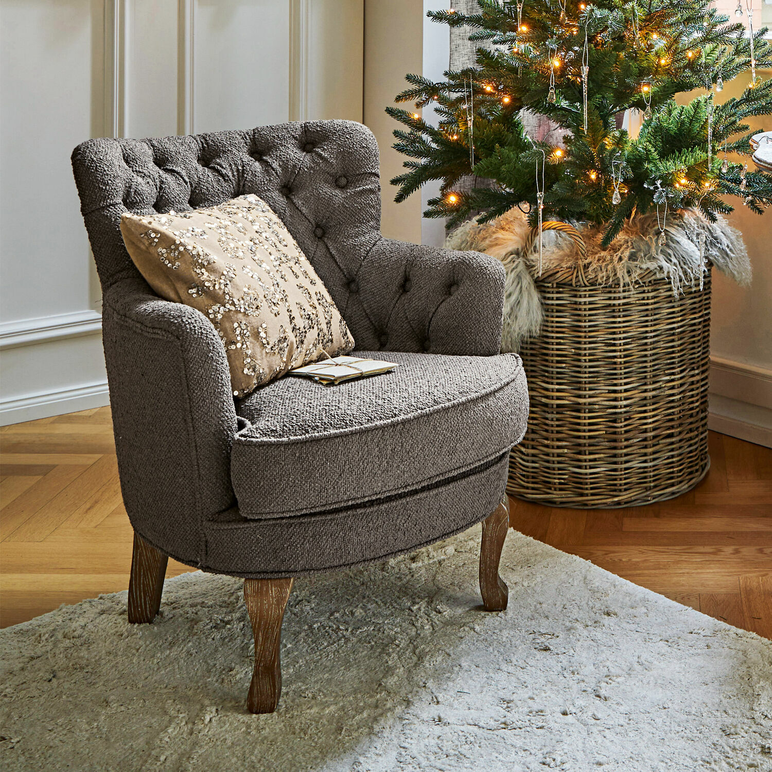 Fauteuil Calgary Fauteuil gris en tissu avec pieds en bois sur tapis clair près d'un sapin de Noël décoré